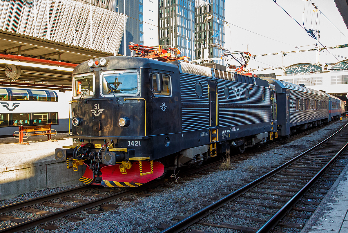 Die SJ Rc6 1421 (S-SJ 91 74 106 1421-3), der schwedische Staatsbahnen Statens Järnvägar, hat am 22.03.2019 mit einem Regionalverkehr Stockholm Central erreicht.

Die Rc 6 wurde 1988 von ASEA (Allmänna Svenska Elektriska Aktiebolaget) in Västerås (Schweden) unter der Fabriknummer 2015 gebaut und an die SJ geliefert. Im Jahr 2001 wurde sie zur Rc7 (auf 180 km/h) umgebaut, aber 2004 wieder auf Rc6 zurückgebaut. ASEA war ein schwedisches Unternehmen, im Februar 1988 legte der Konzern sein Geschäft mit der Schweizer Brown, Boveri & Cie (BBC) zur Asea Brown Boveri (ABB) mit Hauptsitz in Zürich (Schweiz) zusammen.

Die Bauserie Rc6 war die letzte original gebaute schwedischen Rc-Serie. Die 40 Lokomotiven wurden zwischen 1985 und 1988 gebaut und erhielten die Nummer 1383–1422. Wie die Rc3 waren sie ab Werk so ausgelegt, dass ihre Höchstgeschwindigkeit 160 km/h betrug. Zwischen 1992 und 1995 wurden dann auch alle Rc5-Lokomotiven in Rc6 umgebaut, da der Bedarf der SJ an schnellfahrenden Lokomotiven für Reisezüge gestiegen war.

Zwei von den Rc6-Lokomotiven, die 1421 (diese) und die 1422, wurden als Rc7 für 180 km/h umgebaut, um als Lok für Ersatzzüge für die X2000 zu fungieren. Nur die SJ hatte eigentlich keine Reisezugwagen für diese Geschwindigkeit und ein Umbau der Waggons war zu teuer. So wurden die beiden Lokomotiven ein paar Jahre später wieder zurüchgebaut.

TECHNISCHE DATEN der Rc6: 
Hersteller: AESA
Baujahre: 1985 bis 1988
Anzahl: 40 (ursprüngliche Serie)
Spurweite:  1.435 mm (Normalspur)
Achsformel: Bo'Bo'
Länge über Kupplung: 15.520 mm
Drehzapfenabstand: 7.700 mm
Achsabstand im Drehgestell: 2.700 mm
Treibraddurchmesser:  1.300 mm 
Gewicht: 78 t
Höchstgeschwindigkeit: 160 km/h
Leistung: 3.600 kW (4 x 900 kW)
Anfahrzugkraft: 250 kN
Anzahl der Motoren: 4 Stück vom Typ LJM450 á 900 kW
Stromsystem: 15 kV 16 2/3 Hz ~
