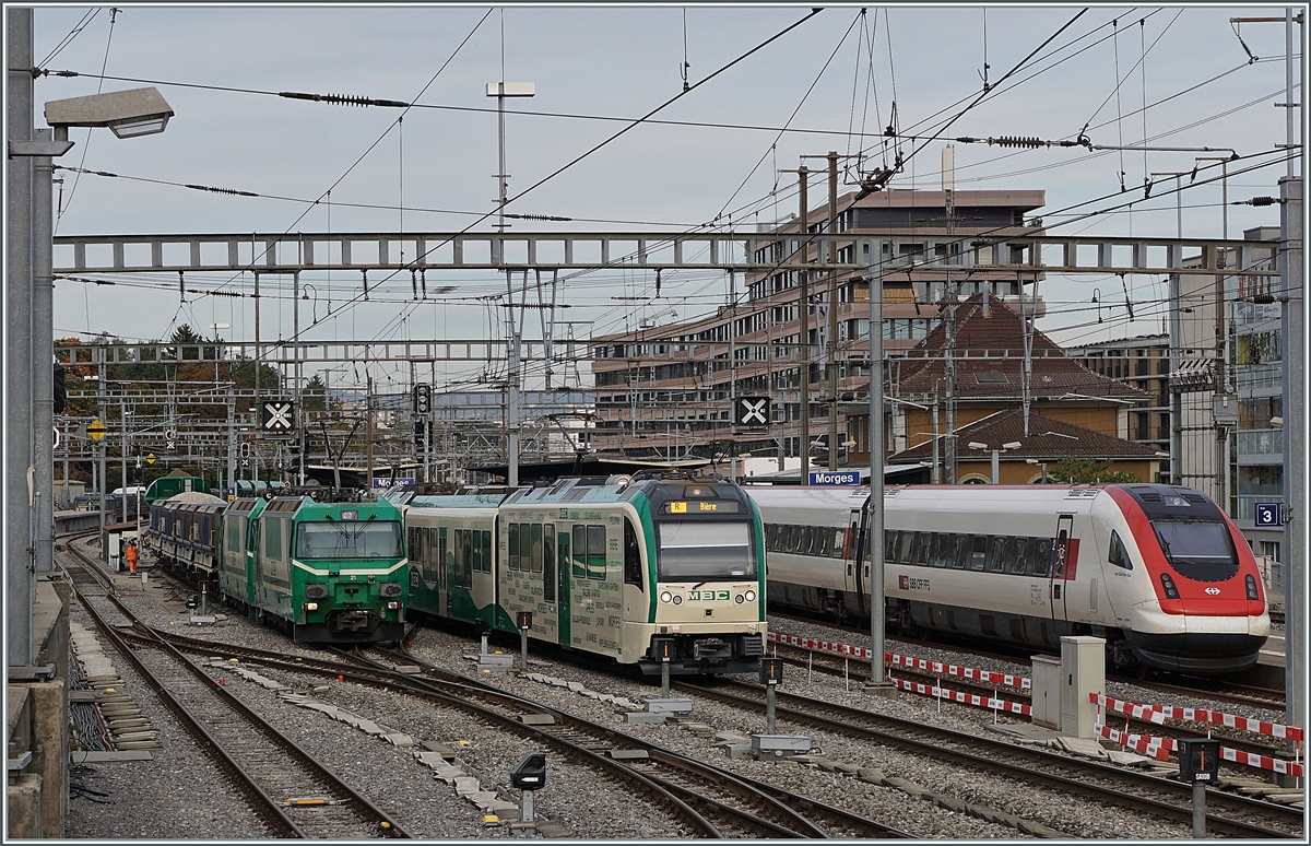 Drei auf einen Streich: Trotz zahlreicher Masten, K�sten und Signale konnte fast unverdeckt diese Szene mit drei Z�gen in Morges aufgenommen werden: Links im Bild wird der Kieszug Apples - Gland mit den beiden BAM MBC Ge 4/4 21 und 22 f�r das Spurwechselman�ver vorbereitet, in der Mitte f�hrt der BAM MBC Regionalzug 144 nach Bi�re aus und rechts im Bild wird ein ICN als IC5 531 nach Z�rich abgefertigt.

18. Oktober 2021