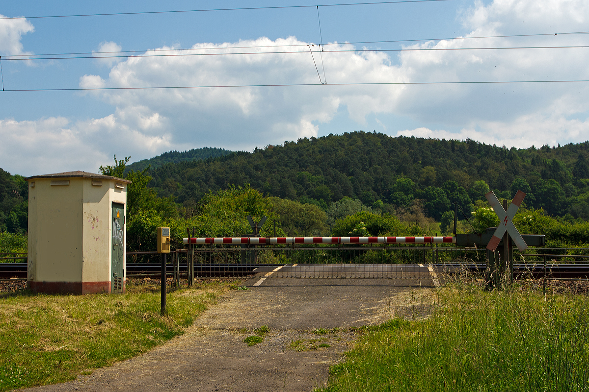 
Eigentlich nur ein Bahnübergang, der Bü km 127,660 bei Dillenburg am 02.06.2014.

Es handelt sich hierbei um eine Anrufschranke, da es nur ein wenig genutzter Bahnübergang an einem Wirtschaftsweg ist. Die Schrankenbäume sind hier grundsätzlich geschlossen und werden nur, sofern dies gefahrlos möglich ist, bei Bedarf geöffnet.

Wenn man den Bahnübergang passieren möchte, so meldet man sich über die Wechselsprechanlage (hier links von der Schranke) beim diensthabenden Schrankenwärter bzw. Fahrdienstleiter. Dieser öffnet dann, wenn es der Zugverkehr zulässt oder kündigt das Öffnen über die Wechselsprechanlage an. Da er den Bahnübergang nicht einsehen kann, wird man aufgefordert, die Räumung dem Wärter zu melden. Bevor er die Schranken wieder schließt, kündigt er das Schließen über die Wechselsprechanlage an. 

Langfristig sollen aus Gründen der Wirtschaftlichkeit Anrufschranken nicht mehr genehmigt werden, sie sollen sukzessive durch gesicherte Bahnübergänge durch Schrankenüberwachung oder eine Gefahrenraum-Freimeldeanlage sowie Rückstauerkennung gesichert werden.
