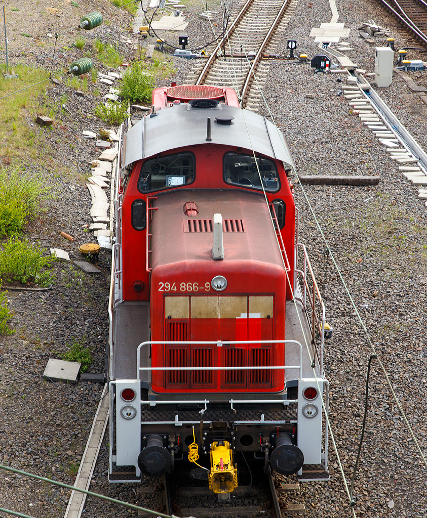 Ein etwas anderer Blick auf eine V 90......

Die 294 866-9 (V 90 remotorisiert) der DB Schenker Rail Deutschland AG, ex DB 294 366-0, ex DB 290 366-4, ist am 02.05.2015 in Kreuztal, bei der Langenauer Br�cke, abgestellt.

Die Lok wurde 1973 bei MaK unter der Fabriknummer 1000641 gebaut und als 290 366-4 an die DB geliefert. Die Ausr�stung mit Funkfernsteuerung und die Umbezeichnung in DB 294 366-0 erfolgte 1999. Die Remotorisierung mit einem MTU-Motor 8V 4000 R41, Einbau einer neuen L�fteranlage, einem neuem Luftpresser und Ausr�stung mit dem Umlaufgel�nder erfolgten 2007 bei der DB Fahrzeuginstandhaltung GmbH im Werk Cottbus. Daraufhin erfolgte die Umzeichnung in 294 866-9. 
Sie hat die kompl. NVR-Nummer 98 80 3294 866-9 D-DB