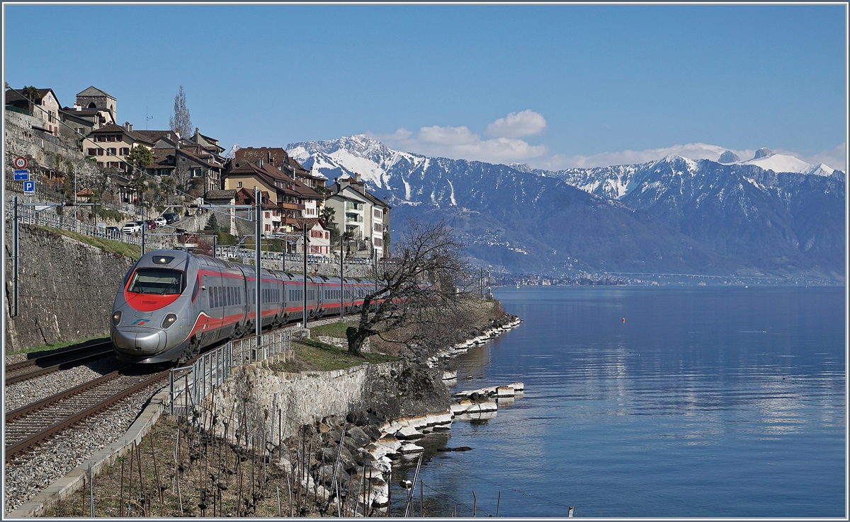 Ein FS Trenitalia ETR 610, als EC 34 von Milano nach Genève unterwegs zeigt sich bei St-Saphorin vor dem Hintergrund des malerischen Ortes und der noch von Schnee bedecken Berge.
24. März 2018