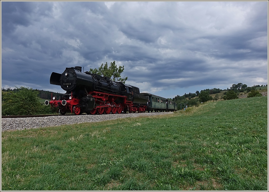 Eine Gewitterfront unterstreicht die mächtige Lokomotive ex DR 53 8163-9 auf ihrer Fahrt nach Les Hôpitaux - Neufs.
(15.07.2023)