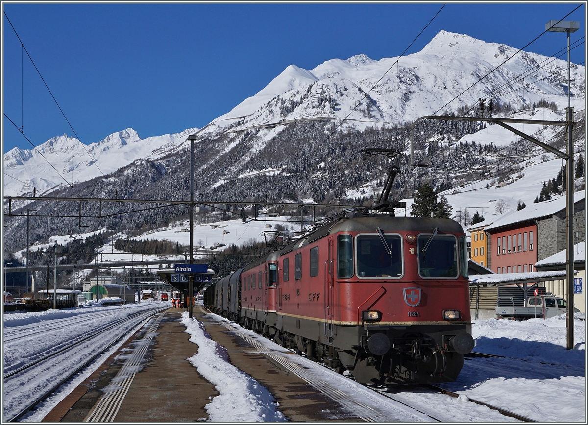 Eine  Re 10/10  mit der Re 4/4 II 11284 als Spitzenlok fährt in Airolo Richtung Süden. 
Im Hintergrund das Gotthard Massiv.
11. Feb. 2016