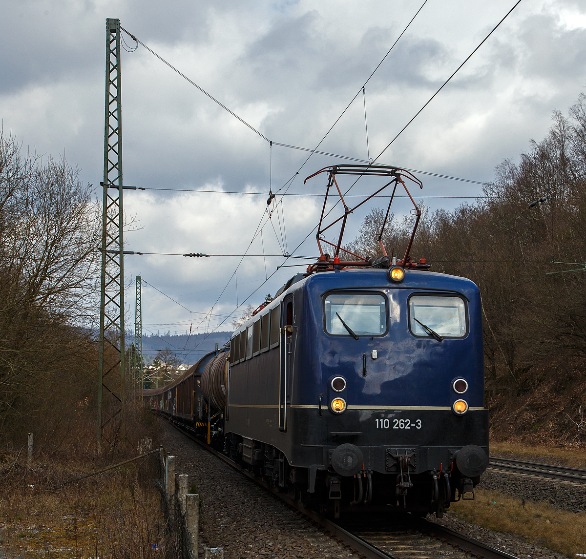 Es steht zwar 110 dran, ist aber 139 drin....
Die 139 262-0 alias 110 262-3 (91 80 6139 262-0 D-BYB) der BayernBahn GmbH rauscht am 26.03.2021, mit dem sogenannten  Henkelzug  (Langenfeld/Rhld. nach Gunzenhausen), auf der Dillstrecke (KBS 445) durch Dillbrecht in s�dlicher Richtung Dillenburg. 

Die 139 262-0 alias 110 262-3 wurde 1962 von Krauss-Maffei AG in M�nchen-Allach unter der Fabriknummer 18921 gebaut, der elektrische Teil ist von den Siemens-Schuckert-Werke (SSW) in Berlin. Als DB E 10 262 wurde in Dienst gesetzt, mit der Einf�hrung des EDV-Nummernsystems wurde sie zum 01.01.1968 zur DB 110 262-3. Zur 139er wurde sie erst 1994, nach dem Erhalt von Drehgestellen der Baureihe 140 (E40). Nach dem Umbau wurde sie in DB 139 262-0 umgezeichnet. Ende April 2012 erfolgte die Z-Stellung bei der DB AG und im Mai 2015 wurde sie an die BayernBahn GmbH verkauft und erhielt anschlie�end eine Untersuchung. Die Neulackierung in stahlblau erhielt sie dann 2016