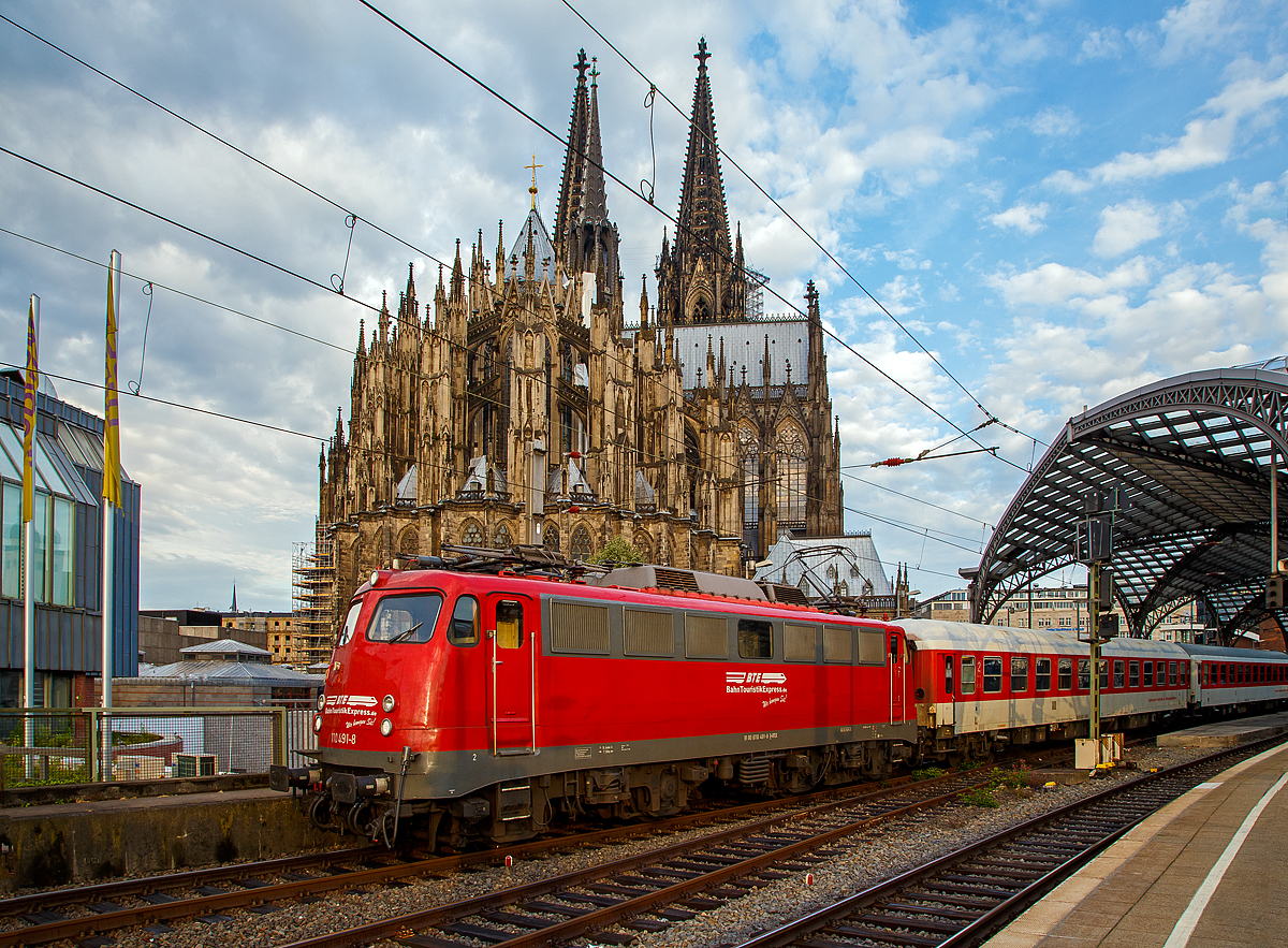 
Fr�h morgens im Hbf K�ln....
Die 110 491-8 der BahnTouristikExpress GmbH (BTE), ex DB 110 491-8, ex DB 114 491-4, ex DB 112 491-6, f�hrt am 22.05.2018 mit einem Sonderzug vom Hbf K�ln in Richtung Hamburg los.

Die Lok wurde 1968 von Krauss-Maffei in M�nchen unter der Fabriknummer 19356 gebaut, der elektrische Teil ist von den Siemens-Schuckert-Werke (SSW), und als 112 491-6 (als eine E 10.12) an die DB ausgeliefert, 1988 wurde sie in 114 491-4 umgezeichnet. Im Jahr 1994 erfolgte der R�ckbau zur 110er unter Verwendung der Drehgestelle der 110 122, somit erfolgte Umzeichnung in 110 491–8. Im Jahr 2014 ging sie an die BahnTouristikExpress GmbH. Nach der Reaktivierung 2015 (und Umbau auf LED-Leuchten, sowie eckige Puffer) f�hrt sie unter der NVR-Nr. 91 80 6110 491-8 D-BTEX.