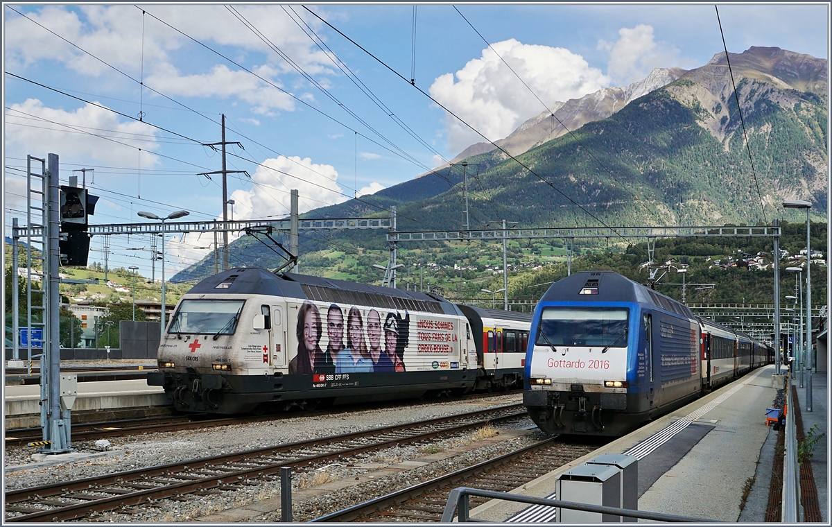 Gleich zwei Werbeloks in Brig: Die Re 460 041-7  Rotes Kreuz  mit ihrem IC nach Romanshorn und die Re 460 079-7  Gotthardo 2016  mit ihrem IR nach Genève Aéroport.
18. Sept. 2017