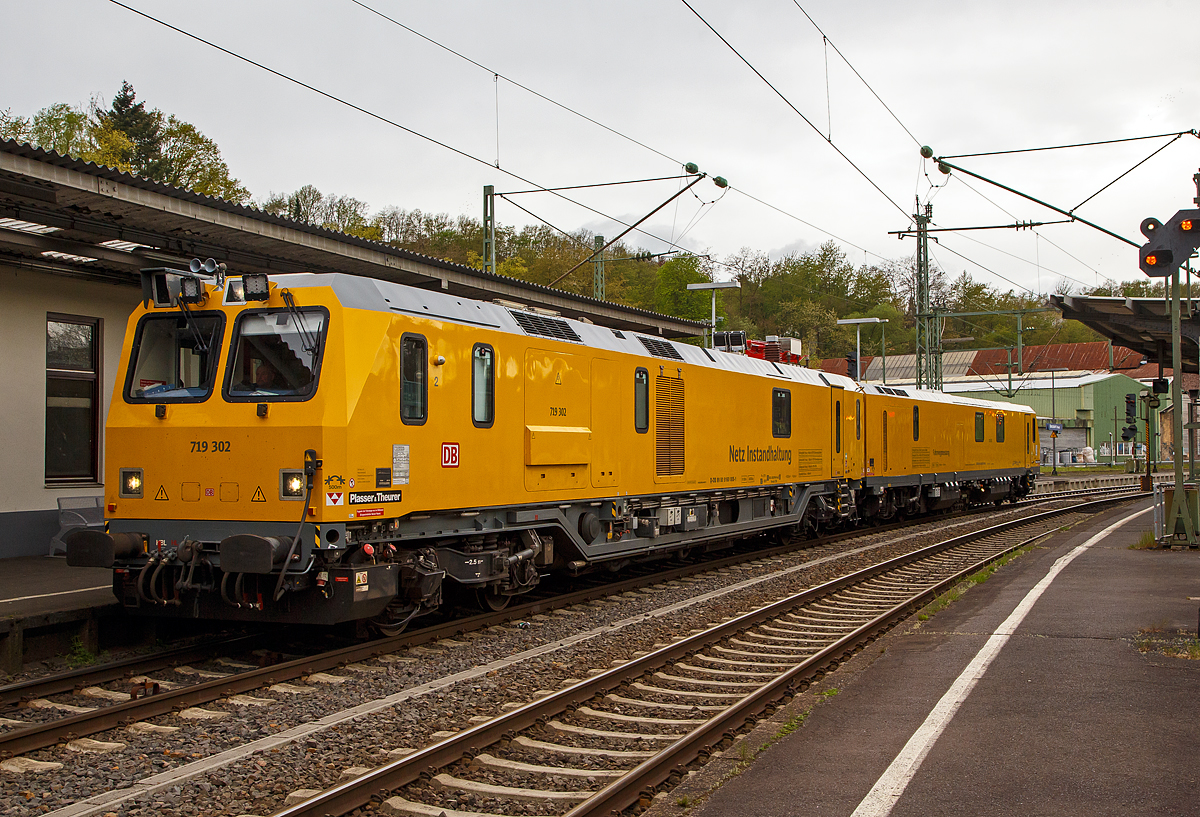 Glück für den Fotografen, das der Schienenprüfzug Hp 0 hatte....
Der Plasser & Theurer Schienenprüfzug (der Bauart SPZ 3) 719 302 / 720 302 (99 80 9160 005-1D-DB / 99 80 9360 008-3 D-DB) der DB Netz AG haete am 10.05.2021 im Bahnhof Betzdorf (Sieg) Hp 0, nun fährt er in Richtung Siegen weiter.

Der Schienenprüfzug wurde 2017 von Plasser & Theurer in Linz (A) unter der Fabriknummer 6048 (SPZ-STW) und  6049 (SPZ-ATW) gebaut.

Um Schäden am Oberbau frühzeitig zu erkennen, setzt die Deutsche Bahn AG verschiedene Prüfzüge der Baureihen 719 und 720 ein. Mittels zweier zerstörungsfreier Prüfverfahren werden die Schienen auf Schädigungen untersucht. Bei der Ultraschallprüfung können Materialfehler durch Materialermüdung innerhalb der Schiene bis zum Schienenfuß erkannt werden. Mit der Wirbelstromprüfung wird der Schienenkopf geprüft. 

Die Schienenprüfzüge der BR 719.3/720.3 wurden ab 2015  von Plasser & Theurer in Linz (A) gebaut. Diese dritte Messtriebwagengeneration entstand in modularisierter Bauweise. Sie basiert auf einer ein- und zweiteiligen Messwagenfamilie, die Ende 2012 von der DB bestellt wurde. Die Schienenprüfzüge sind zweiteilig ausgeführt und bestehen aus einem allachsgetriebenen Trieb- (ATW) und einem Steuerwagen (STW). Beide Wagen sind 23 Meter lang. Der ATW hat ein Eigengewicht von 81 t, der STW 67 t. Der Triebzug hat eine Höchstgeschwindigkeit von 140 km/h.
Unter dem Bodenrahmen des Steuerwagens sind zwischen den Drehgestellen ein absenkbarer Messwagen und zwei Wasserbehälter für die ZfP-Sensorik aufgehängt. Auf dem Dach des Triebwagens sitzt ein Messstromabnehmer. Als Antrieb dienen zwei Deutz-Dieselmotoren. Im hinteren Teil des Triebwagens gibt es eine klimatisierte Küche mit Mikrowelle, Herd, Spüle, Tisch und Sitzecke mit Wifi sowie eine Toilette. Im Steuerwagen sind neben dem Beobachtungsstand mit neun Monitoren eine Werkstatt mit Ersatzteillager und Kalibriergeräten, Schaltschränke mit Messtechnik, vier Schlafabteile und der Führerstand 1 untergebracht. Die Ultraschall- und Wirbelstrommesstechnik wurde von der Firma PLR Magdeburg geliefert. 

