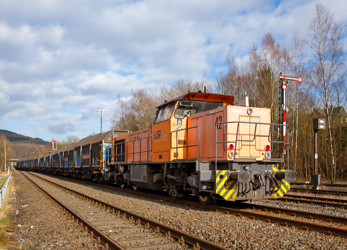 
Güterverkehr im Hellertal....
Die KSW (Kreisbahn Siegen-Wittgenstein) kommt mit einem beladenen Coilzug (Teleskophaubenwagen der Gattung Shimmns 2) am 15.03.2016 durch Herdorf, und fährt gleich vom DB Gleis aufs KSW Gleis, dann geht es weiter via Neunkirchen nach Neunkirchen-Salchendorf auf den Pfannenberg. 

Im Nachschuss sieht man hier gut die Schublok, dieser war die Lok 42  (92 80 1277 902-3 D-KSW) eine Vossloh MaK G 1700 BB, während die ziehende Lok 44 (92 80 1271 004-4 D-KSW) eine MaK G 1000 BB nun bereits die Anschlußstelle erreicht.