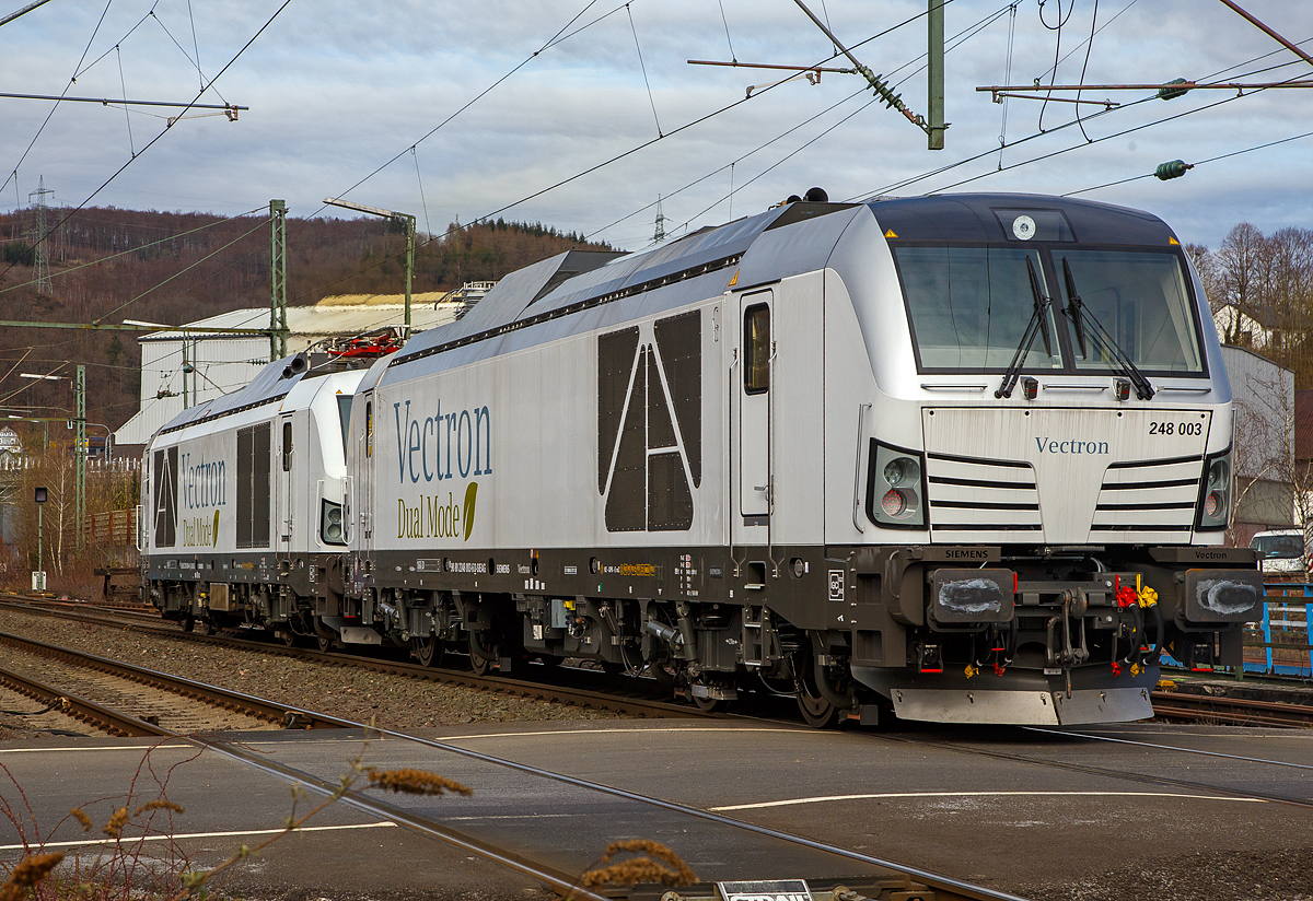 Hat da jemand vielleicht die Stromrechnung nicht bezahlt.... 
Denn die beiden Siemens Vectron Dual Mode Loks, 248 004 (90 80 2248 004-4 D-SIEAG) und die 248 003 (90 80 2248 003-6 D-SIEAG) der Siemens Mobility GmbH, fahren am 20.03.2021, mit abgesenkten Stromabnehmern als Lokzug, obwohl die Strecke elektrifiziert ist, über die Siegstrecke (KBS 460) durch Niederschelden in Richtung Siegen. 

Beide Vectron DM wurden 2020 von Siemens Mobility GmbH in München-Allach gebaut, die 248 004 unter der Fabriknummer 22927 und die 248 003 unter der Fabriknummer 22926. Am 29. Oktober 2020 wurde vom Eisenbahn-Bundesamt (EBA) die Zulassung für den Betrieb der Siemens Vectron Dual Mode Loks in Deutschland erteilt. Einige Unternehmen haben sie auch schon bestellt. Auch die DB Cargo bestellte 100 Zweikraftlokomotiven im September 2020 der auf Basis der Baureihe 248, mit einer Option über weitere 300 Loks. Die Auslieferung startet ab 2023. Die DB Loks sind aber stark modifiziert, so soll bei ihnen die Achslast maximal 21 t betragen (statt 22,5 t).

Hybrid muss nicht immer Akkunutzung heißen. Siemens neue Vectron hat neben der Elektrofähigkeit unter Fahrdraht auch einen Dieselmotor.

Der Vectron Dual Mode vereint die Vorteile einer vollwertigen Diesellokomotive mit denen von elektrischen Lokomotiven. Dank des leistungsstarken Dieselantriebs sowie der Ausstattung für die Nutzung der Fahrleitung kann man jederzeit flexibel auf die Traktionsanforderungen reagieren. So bleibt man immer in Bewegung, egal ob mit oder ohne Fahrdraht. Wo ein Fahrdraht ist, sollte man ihn nutzen. Denn der Betrieb unter Oberleitung ist im Vergleich zum Dieselbetrieb deutlich kosteneffizienter und umweltfreundlicher. Doch weil es in Deutschland noch lange Zeit Strecken geben wird, die nicht vollständig elektrifiziert sind, fahren viele Diesellokomotiven unter Fahrdraht weiter. Das ist aber ökonomisch und ökologisch wenig sinnvoll. Dies ist hier ein Beispiel einer echten Alternative. 

Mit der Vectron Dual Mode ist es möglich Güterzüge aus dem Umland umweltschonend in die Zentren der Ballungsräume zu befördern. Nur so einfach, wie in der Siemens Werbung ist es auch nicht, denn die Lok vier Achsen (Bo’Bo’) und wiegt 90 t, so ergibt sich eine Achslast  von 22,5 t. Nicht elektrifizierte Nebenstrecken haben nicht gerade alle von min. D2 (22,5 t), und können so auch nicht befahren werden. Auch die Leistung der DM im Vergleich zu heutigen Hochleistungselektrolokomotiven ist mit 2.400 kW erheblich geringer. Mit den Dieselstreckenlos kann sie aber mit 2.000 kW sehr gut mithalten, zudem liegt die Anfahrzugskraft bei stattlichen 300 kN.

TECHNISCHE DATEN der Siemens Vectron Dual Mode (BR 248)
Spurweite: 1.435 mm
Achsformel: Bo'Bo'
Länge über Puffer: 19.975 mm
Drehzapfenabstand: 10.800 mm
Achsabstand im Drehgestell: 2.700 mm
Breite: 3.020mm
Höhe:  4.220 mm
Raddurchmesser :  1.100 mm (neu) / 1.020 mm (abgenutzt)
Gewicht:  90 t (bei vollen Vorräten)
Achslast: 22,5 t
Spannungssysteme (bei E-Betrieb): 15 kV, 16,7 Hz
Dieselmotor: MTU 16V 4000 R84 (16-Zylinder-V-Motor)
Dieselmotorleistung an der Kurbelwelle: 2.400 kW
Max. Leistung am Rad: 2.400 kW bei E-Antrieb / 2.000 kW bei D-Antrieb
Höchstgeschwindigkeit:160 km/h
Antriebsart: elektrisch oder dieselelektrisch
Kraftübertragung :Teilabgefederter Antrieb (Ritzelhohlwellenantrieb)
Kraftstoffbehälter Nutzvolumen: 2.600 l
Anfahrzugskraft:  300 kN
Elektrische Bremskraft: 150 kN
Elektrische Bremsleistung (am Rad): E-Betrieb 2.100 kW / Dieselbetrieb 1.700 kW
Doppeltraktion: Über WTB ÖBB mit typgleichen Fahrzeugen sowie Vectron E, Vectron DE und ER20
Zugsicherung: PZB / für ETCS vorbereitet

