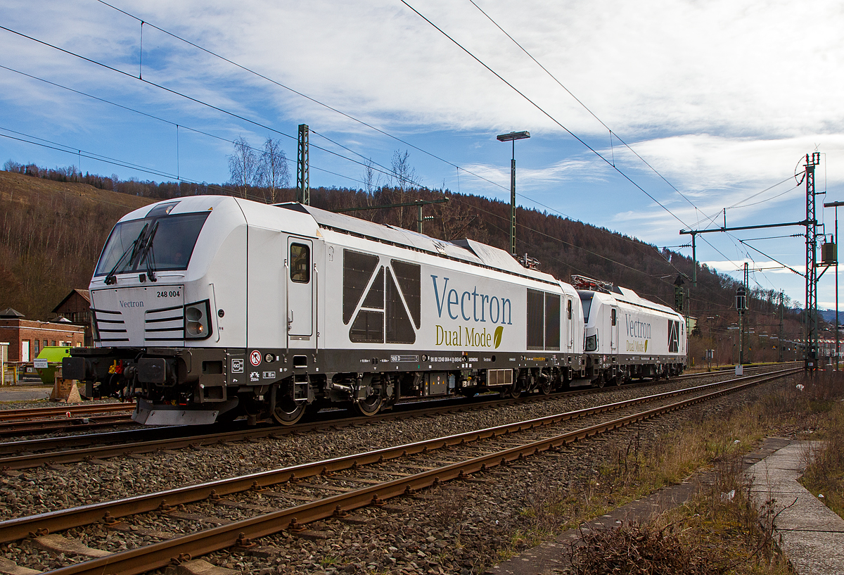 Hat da jemand vielleicht die Stromrechnung nicht bezahlt.... 
Denn die beiden Siemens Vectron Dual Mode Loks, 248 004 (90 80 2248 004-4 D-SIEAG) und die 248 003 (90 80 2248 003-6 D-SIEAG) der Siemens Mobility GmbH, fahren am 20.03.2021, mit abgesenkten Stromabnehmern als Lokzug, obwohl die Strecke elektrifiziert ist, über die Siegstrecke (KBS 460) durch Niederschelden in Richtung Siegen. 

Beide Vectron DM wurden 2020 von Siemens Mobility GmbH in München-Allach gebaut, die 248 004 unter der Fabriknummer 22927 und die 248 003 unter der Fabriknummer 22926. Am 29. Oktober 2020 wurde vom Eisenbahn-Bundesamt (EBA) die Zulassung für den Betrieb der Siemens Vectron Dual Mode Loks in Deutschland erteilt. Einige Unternehmen haben sie auch schon bestellt. Auch die DB Cargo bestellte 100 Zweikraftlokomotiven im September 2020 der auf Basis der Baureihe 248, mit einer Option über weitere 300 Loks. Die Auslieferung startet ab 2023. Die DB Loks sind aber stark modifiziert, so soll bei ihnen die Achslast maximal 21 t betragen (statt 22,5 t).

Hybrid muss nicht immer Akkunutzung heißen. Siemens neue Vectron hat neben der Elektrofähigkeit unter Fahrdraht auch einen Dieselmotor.

Der Vectron Dual Mode vereint die Vorteile einer vollwertigen Diesellokomotive mit denen von elektrischen Lokomotiven. Dank des leistungsstarken Dieselantriebs sowie der Ausstattung für die Nutzung der Fahrleitung kann man jederzeit flexibel auf die Traktionsanforderungen reagieren. So bleibt man immer in Bewegung, egal ob mit oder ohne Fahrdraht. Wo ein Fahrdraht ist, sollte man ihn nutzen. Denn der Betrieb unter Oberleitung ist im Vergleich zum Dieselbetrieb deutlich kosteneffizienter und umweltfreundlicher. Doch weil es in Deutschland noch lange Zeit Strecken geben wird, die nicht vollständig elektrifiziert sind, fahren viele Diesellokomotiven unter Fahrdraht weiter. Das ist aber ökonomisch und ökologisch wenig sinnvoll. Dies ist hier ein Beispiel einer echten Alternative. 

Mit der Vectron Dual Mode ist es möglich Güterzüge aus dem Umland umweltschonend in die Zentren der Ballungsräume zu befördern. Nur so einfach, wie in der Siemens Werbung ist es auch nicht, denn die Lok vier Achsen (Bo’Bo’) und wiegt 90 t, so ergibt sich eine Achslast  von 22,5 t. Nicht elektrifizierte Nebenstrecken haben nicht gerade alle von min. D2 (22,5 t), und können so auch nicht befahren werden. Auch die Leistung der DM im Vergleich zu heutigen Hochleistungselektrolokomotiven ist mit 2.400 kW erheblich geringer. Mit den Dieselstreckenlos kann sie aber mit 2.000 kW sehr gut mithalten, zudem liegt die Anfahrzugskraft bei stattlichen 300 kN.

TECHNISCHE DATEN der Siemens Vectron Dual Mode (BR 248)
Spurweite: 1.435 mm
Achsformel: Bo'Bo'
Länge über Puffer: 19.975 mm
Drehzapfenabstand: 10.800 mm
Achsabstand im Drehgestell: 2.700 mm
Breite: 3.020mm
Höhe:  4.220 mm
Raddurchmesser :  1.100 mm (neu) / 1.020 mm (abgenutzt)
Gewicht:  90 t (bei vollen Vorräten)
Achslast: 22,5 t
Spannungssysteme (bei E-Betrieb): 15 kV, 16,7 Hz
Dieselmotor: MTU 16V 4000 R84 (16-Zylinder-V-Motor)
Dieselmotorleistung an der Kurbelwelle: 2.400 kW
Max. Leistung am Rad: 2.400 kW bei E-Antrieb / 2.000 kW bei D-Antrieb
Höchstgeschwindigkeit:160 km/h
Antriebsart: elektrisch oder dieselelektrisch
Kraftübertragung :Teilabgefederter Antrieb (Ritzelhohlwellenantrieb)
Kraftstoffbehälter Nutzvolumen: 2.600 l
Anfahrzugskraft:  300 kN
Elektrische Bremskraft: 150 kN
Elektrische Bremsleistung (am Rad): E-Betrieb 2.100 kW / Dieselbetrieb 1.700 kW
Doppeltraktion: Über WTB ÖBB mit typgleichen Fahrzeugen sowie Vectron E, Vectron DE und ER20
Zugsicherung: PZB / für ETCS vorbereitet