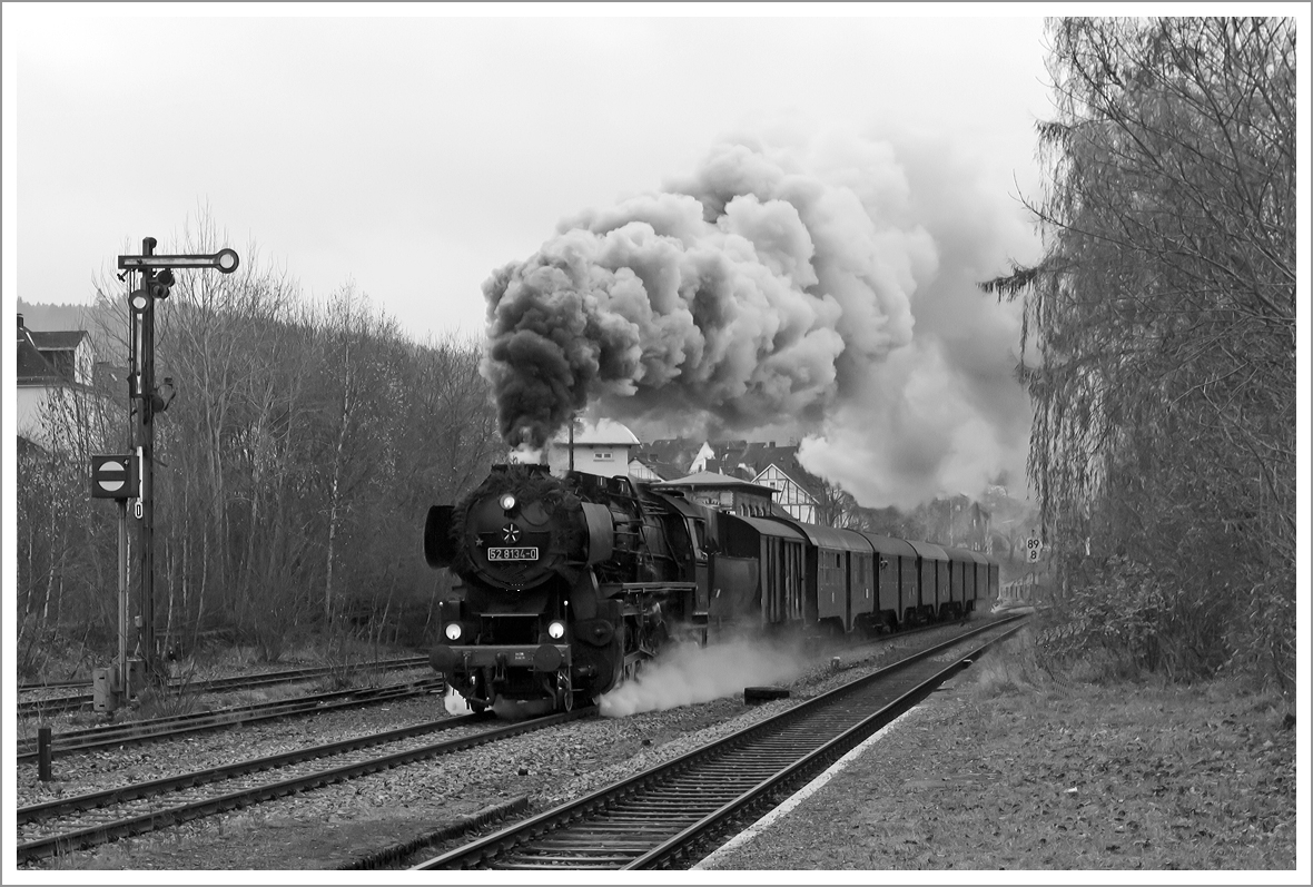 Herdorf Anno 1963 - Die Betzdorfer 52 8134-0 zieht mit m�chtiger Rauchfahne dem Mittagszug.... 

Nein im Ernst mit m�chtiger Rauchfahne durchf�hrt die Betzdorfer 52 8134-0 am 01.12.2013 Herdorf, hier kurz vor dem Bahnhof. Heute veranstalten die Eisenbahnfreunden Betzdorf ihre allj�hrlichen Nikolausfahrten zwischen Betzdorf/Sieg und W�rgendorf.

Die Lok war, bedingt durch die Wiedervereinigung, eine der letzten Normalspurigen Dampfloks der DB.  Zudem war sie als 052 134-4 die einzige wahre 52 der DB (BR 52.80). Die Lok wurde 1965 aus der 1943 bei der Lokfabrik Wien-Floridsdorf (Fabriknummer 16591) gebauten 52 7138 rekonstruiert.
