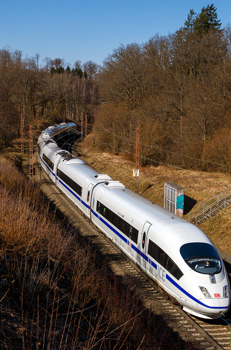 Highlight des Tages.... Wenn der Prophet nicht zum Berg kommt, dann muss der Berg halt zum Propheten...
Der ICE 3 M – Triebzug 4601 – DB 406 501-7 / 406 001-8 „Europa/Europe“ mit Blauen Streifen der DB Fernverkehr AG fährt am 07.03.2022 bei Wilnsdorf-Ruderdorf (Kr. Siegen) über die Dillstecke in Richtung Frankfurt. Gleich geht es in den 2.652 m langen Rudersdorfer Tunnel.

Einen lieben Gruß an den freundlich grüßenden Lokführer zurück. Sorry, ich hatte den Gruß durch den Sucher nicht gesehen.

Der Triebzug wurde 2001 gebaut, er besteht auch acht Wagen, im Einzelnen aus dem:
Endwagen 8   UIC-Nr. 406 501-7
Trafowagen 7   UIC-Nr. 406 601-5
Stromrichterwagen 6  UIC-Nr. 406 701-3
Mittelwagen 5   UIC-Nr. 406 801-1
Mittelwagen 4   UIC-Nr.  406 301-2
Stromrichterwagen 3  UIC-Nr 406 201-4
Trafowagen 2   UIC-Nr. 406 101-6
Endwagen 1   UIC-Nr.  406 001-8

Der Triebzug hat die Zulassungen für Deutschland, Belgien (ETCS) und die  Niederlande. Der ICE 3M ist eine Triebwagenzug und nicht wie ICE 1 und 2 mit Triebkopfkonzept. Gegenüber den äußerlich gleichen ICE 3 (BR 403) sind sie mehrsystemfähig (15 kV 16,7 Hz~ / 25 kV 50 Hz~ / 1,5 kV = / 3 kV =). In Deutschland fahren sie planmäßig bis zu 300 km/h (technisch möglich und zugelassen 330 km/h). Unter Gleichstrom (wie in Belgien 220 km/h).