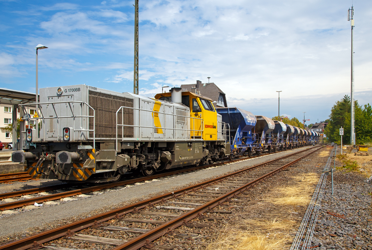 
Im Bauzugdienst....

Die 277 031-1 (92 80 1277 031-1 D-LDS) eine Vossloh G 1700-2 BB der Schweerbau schiebt ihren Schotterzug am 21.07.2018 von Altenkirchen (Ww) in Richtung Au (Sieg). Hinter dem Bahnhof beginnt das Baugleis, die Strecke zwischen Altenkirchen und Au wird z.Z. erneuert.  Blind wird jedoch nicht gefahren, am ersten Wagen steht ein Rangierer der mit Sprechfunk mit dem Lokführer verbunden ist.

Die MaK G 1700-2 BB wurde 2011 unter der Fabriknummer 5001870 bei Vossloh in Kiel gebaut, seit 2012 ist sie Eigentum der Schweerbau, jedoch eingestellt bei LDS GmbH Logistik, Dienstleistungen & Service (Eutin)