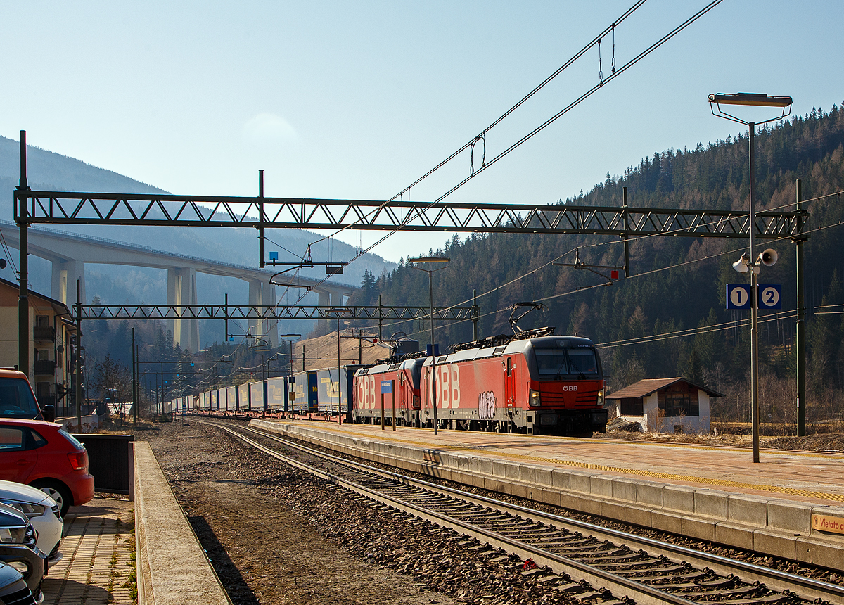 In Doppeltraktion fahren die beiden ÖBB Vectron MS 1293 043-6 und 1293 037-8 am 28.03.2022 mit einem langen „LKW-Walter“-KLV-Zug durch den Bahnhof Gossensaß/Colle Isarco zum Brenner/Brennero hinauf.

Im Hintergrund das Wipptal überbrückende Gossensaß-Viadukt (Viadotto Colle Isarco) der Brennerautobahn. Noch fahren auf der Brennerautobahn teilweise LKW an LKW, mit der 2032 geplanten Eröffnung von dem 64 km langen Brennerbasistunnel (BBT), soll dies dann vorbei sein. Dann ist man mit der Bahn von München viel schneller in Verona oder Venedig, aber dann ist für uns Bahnfotografen auch nichts mehr viel los auf der Brennerbahn (Ferrovia del Brennero).
