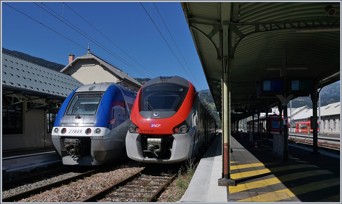 In St-Gervais Les Bains Le Fayet wartet der SNCF Z 27685 als TER 884662 auf die baldige Abfahrt nach Annemasse, während der SNCF Coradia Polyvalent régional tricourant Z 31517 M eine Stunde später als Léman Express L3 23482 nach Coppet fahren wird.

Rechts im Bild, leider nur angeschnitten, Triebzüge der Schmalspurban nach Vallorcine (-Martigny) 

7. Juli 2020