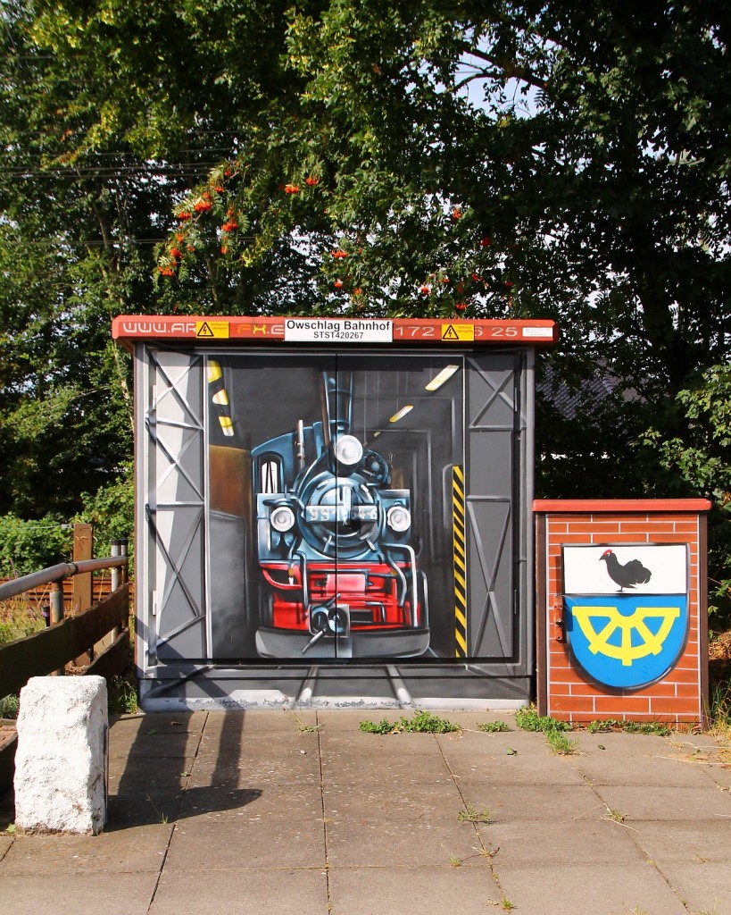 Kunstvoll verziehrte Schaltwerkstation für den Bhf Owschlag wohl zu Ehren der DR 99 1564-6/99 564(DB Betriebsnummer 099 705-6, SMF Chemnitz, Bj 1909, Bauart B´B´n4v, Fabriknr: 3217, 22,4 bis 28,5t, 178 kw Vamx 30km/h), seitlich wird ein Lokschuppen angedeutet der aber durch den privaten Zaun teilverdeckt wird, ein Foto wurde daher nicht erstellt. Owschlag 04.08.2014