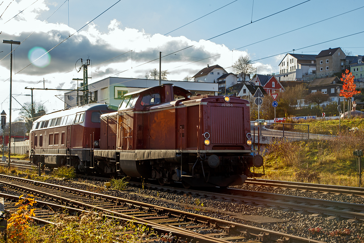 Leider im starken Gegenlicht....
Die 212 325-5 (92 80 1212 325-5 D-EFW), ex DB V 100 2325, mit der 215 023-3 eigentlich 225 023-1 (92 80 1225 023-1 D-EFW) im Schlepp als Lz (Lokzug) am 22.11.2021 durch Niederschelden in Richtung Siegen. Beide Loks gehören der EfW-Verkehrsgesellschaft mbH. 

Die V 100.20 (212 325-5) wurde 1966 MaK in Kiel unter der Fabriknummer 1000372 gebaut und als V 100 2325 an die Deutsche Bundesbahn geliefert. Zum 01.01.1968 Umzeichnung in DB 212 325-5. Z-Stellung und Ausmusterung bei der DB im Jahr 2001. Im Jahr 2002 über ALS - ALSTOM Lokomotiven Service GmbH in Stendal an die EBM Cargo GmbH & Co. KG dann 2005 an TSD - Transport-Schienen-Dienst GmbH, teilweise als Mietlok. Seit 2010 ist sie nun auch bei der EfW-Verkehrsgesellschaft mbH.

Die V 163 (225 023-1) wurde 1970 bei Krupp in Essen unter der Fabriknummer 5044 gebaut an die DB geliefert. Im Jahr 2001 erfolgte der Umbau und Umzeichnung in DB 225 023-1. Seit 2013 ist sie bei der EFW. Sie ist für Steilstrecken zugelassen und besitzt zusätzlich die belgische Zugsicherung.