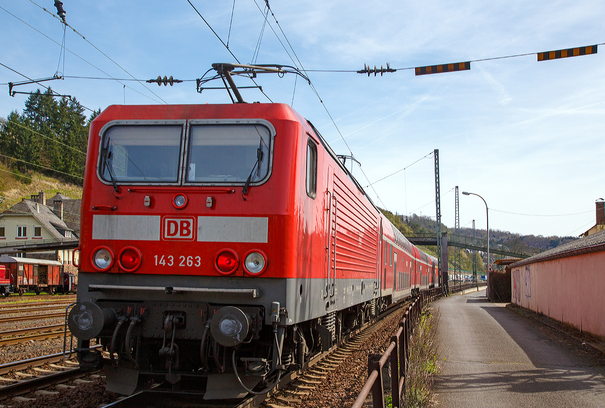 
Mit beiden gehobenen Stromabnehmern ist schon bei Wechselstrom (15 kV 16,7 Hz) sehr ungew�hnlich....
Die 143 263-2 (91 80 6143 263-2 D-DB) der DB Regio S�dwest erreicht gleich, mit dem RB 27  Rhein-Erft-Bahn  (M�nchengladbach - K�ln - Bonn-Beuel - Neuwied - Koblenz Hbf), den Bahnhof Linz am Rhein, hier am 12.04.2015. 

Die Lok wurde 1987 bei LEW (VEB Lokomotivbau Elektrotechnische Werke Hans Beimler Hennigsdorf) unter der Fabriknummer 20146 gebaut und als DR 243 263-1an die Deutsche Reichsbahn geliefert, 1992 erfolgte die Umzeichnung in DR 143 263-2 und zum 01.01.1994 in DB 143 263-2. 

Ein Umbau (Einbau) Notbrems�berbr�ckung (NB�) und elektropneumatischer Bremse (ep) erfolgte 2007 und 2010 die Hochr�stung auf NB� 2004. Die Notbrems�berbr�ckung (NB�) dient bei Personenz�gen dazu, den Zug trotz bet�tigter Notbremse weiterfahren zu lassen und erst an einem besser geeigneten Ort zum Stillstand zu bringen. Grund f�r ihre Einf�hrung war, dass das Halten eines brennenden Zuges in einem Tunnel zu verheerenden Folgen f�hren kann, aber auch, dass ein Zug, der an einem schwer zug�nglichen Punkt zum Stehen kommt, die Bergung erschwert. 

Die Notbrems�berbr�ckung darf aber vom Triebfahrzeugf�hrer nur in besonders gekennzeichneten Streckenabschnitten angewandt werden. Bei der NB� 2004 f�hrt die Bet�tigung einer Notbremse allerdings zun�chst nur zu einer optischen und akustischen Meldung im F�hrerstand. Der Triebfahrzeugf�hrer muss diese Meldung entweder durch einen �berbr�ckungsbefehl oder durch eine Schnellbremsung best�tigen. Andernfalls wird die Notbremsung nach kurzer Zeit selbstt�tig wirksam. 