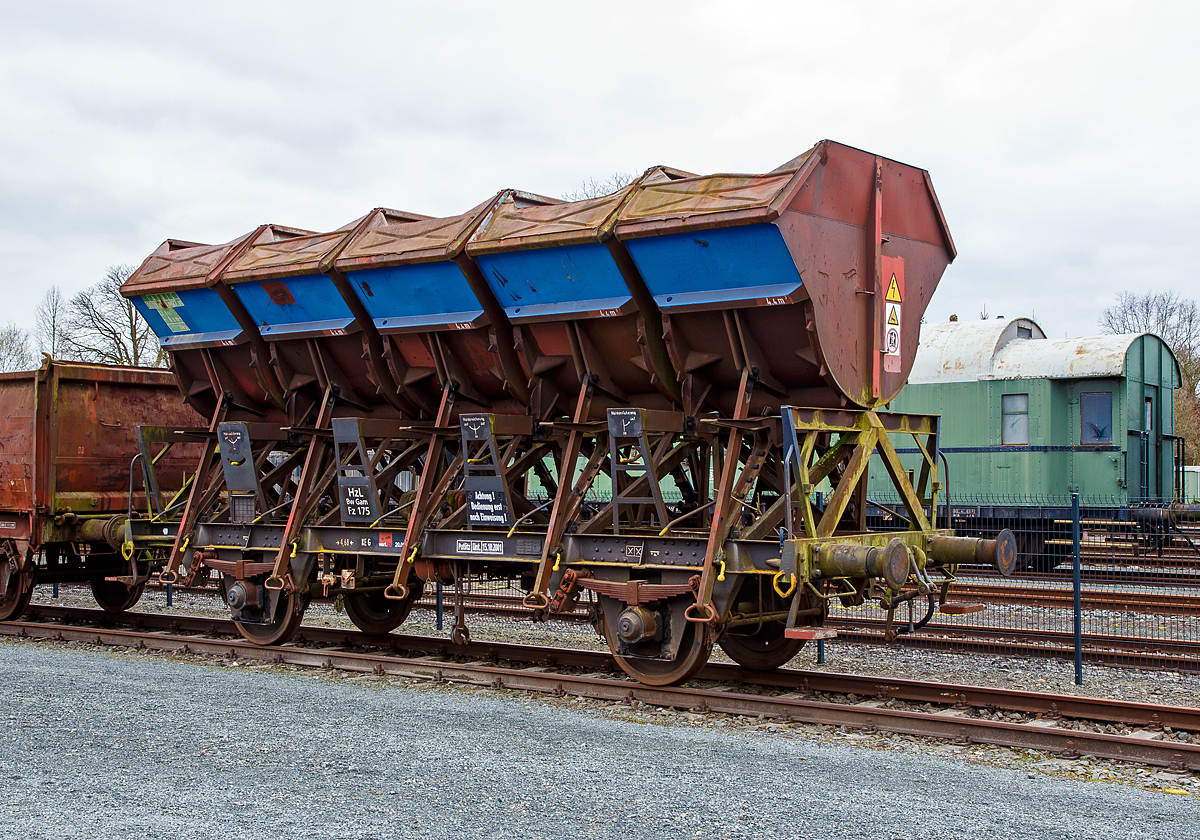 Muldenkippwagen, ex Fz 175 der Hohenzollerischen Landesbahn (HzL) am 26.03.2016 ausgestellt im Deutschen Dampflokomotiv-Museum in Neuenmarkt-Wirsberg. Bei dem Wagen handelt es sich vermutlich um den ex DB 21 80 600 0 342, der Gattung F-z 120 (ex Ommi 51).

Zwischen 1952 und 1970 beschaffte die Deutsche Bundesbahn insgesamt 3.905 zweiachsige Muldenkippwagen, die zun�chst als Ommi 51 (ab 1968: F-z 120) in Dienst gestellt werden. Der Clou war, die Ladung nicht in einem Trichter zu transportieren, wie bis Anfang der 1950er Jahre nur in den Trichterwagen der Bauart Otm. Sondern f�nf einzelne Mulden zu bauen, die auch einzeln entladen werden konnten. Jede Mulde hatte ein Fassungsverm�gen von 4,4 m�. Bis 1970 wurden 3905 Wagen in Dienst gestellt. 

Diese Wagen eigneten sich f�r n�sseunempfindliche Sch�ttg�ter verschiedener Art (wie z.B. wie Schotter, Kohle, Sand und Steine). Seine f�nf Mulden sind nach beiden Seiten kippbar und k�nnen, aufgrund der H�he der Mulden, das Sch�ttgut direkt und bequem auf einen daneben stehenden Lkw, oder �ber eine Bunkermauer hinweg abgeben. Dabei ist er von nur einem Mann bedienbar. 

F�r die Bedienung der Wagen gab es aber extra eine Dienstanweisung. Da die Bedienung nicht ganz einfach war, waren die Wagen nur innerhalb der DB zugelassen. Es durfte auch nur jeweils eine Mulde gekippt werden, da sonst die Gefahr bestand dass der Wagen umkippte. 

Beladen werden konnten die Wagen nur von oben, z.B. �ber eine Sch�ttgutvorrichtung. Der Laderaum umfasste 22 m� und darin konnten G�ter von bis zu 27 t transportiert werden. Die Wagen waren recht langlebig, nach 53 Jahren wurde 2006 die letzten Wagen ausgemustert.

Konstruktion des Wagens:
Das aus Walzprofilen geschwei�te Untergestell tr�gt waagerechte Abrollbahnen, auf denen die mit F�hrungszapfen versehenen Wiegen der Mulden abrollen k�nnen. Die Mulden lassen sich teilweise oder vollst�ndig entladen. Die Mulde kann in der gew�hlten Kippstellung festgehalten und arretiert werden. Nach dem Ausklinken der R�cklaufverriegelung rollt die entleerte Mulde in ihre Normalstellung zur�ck und die Muldensicherung rastet selbstt�tig ein.

TECHNISCHE DATEN:
Spurweite: 1.435 mm (Normalspur)
Achsanzahl: 2
L�nge �ber Puffer: 9.000 mm
Achsabstand: 4.680 mm
Wagenh�he: 4.090 mm
Breite �ber Alles: 2.780 mm
L�nge der Belade�ffnung: 5 � 1.352 mm
Volumen der Mulden: 5 x 4,4 m� = 22 m�
Eigengewicht: 12.190 kg
Max. Zuladung: 27.000 kg (ab Streckenklasse C)
H�chstgeschwindigkeit: 90 km/h
Intern. Verwendungsf�higkeit: nein (nur DB)
