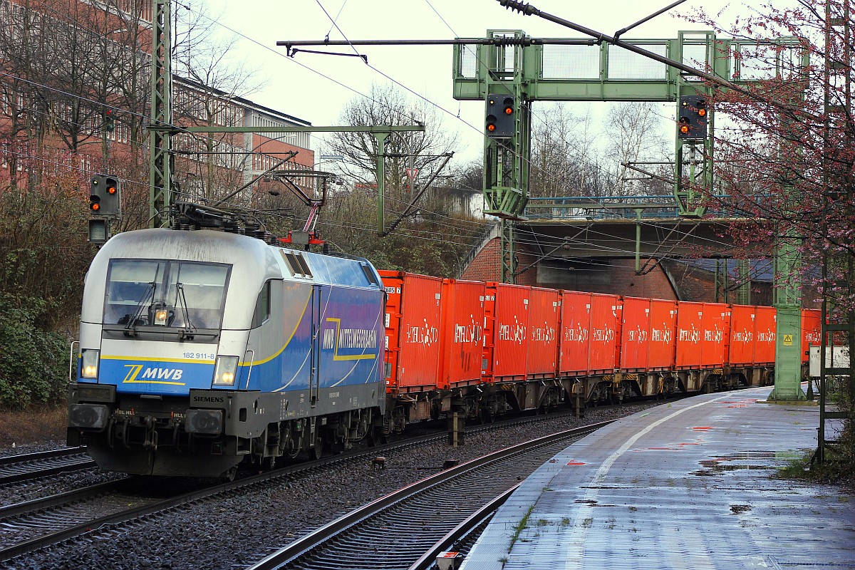 Nach dem Hagel-Schauer kam die MWB 182 911-8(ex ÖBB 1116 131-2/1116 911-7, UNT/LD X/15.11.07, Verl/NNR/14.11.15) mit einem  Hamburg-Süd  Containerganzzug durch HH-Harburg gefahren. 01.04.2015