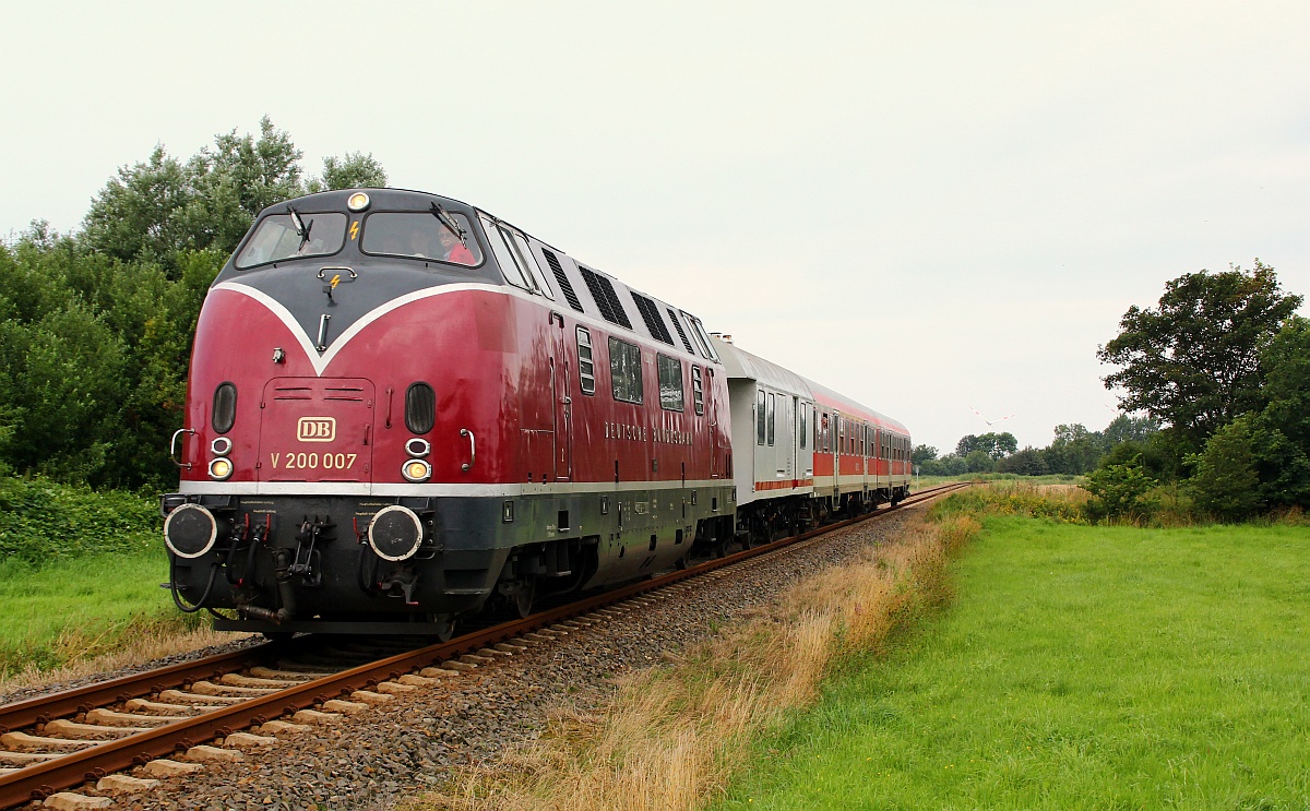 Niebüller Dampf...Diesel-Tage 2012: Auf Grund des Ausfalls der eigentlichen Dampflok aus Kappel übernahm die V 200 007/220 007-9 aus Lübeck die Aufgabe die täglichen Züge der neg von Niebüll nach Dagebüll und zurück zu befördern. Hier passiert die Lok mit dem dazugehörigen Trafowagen und zwei n-Wagen der DB einen Bü am Kronkroogsdeich auf dem Weg nach Dagebüll. Niebüll/Kronkoogsdeich 04.08.2012(üaVinG)