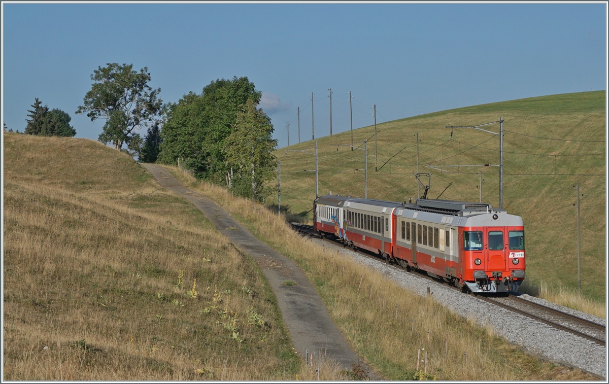 Noch ein letztes Mal vor dem Angebostswechsel am 7. Aug. wollte ich den  TRAVYS  Schülerzug fotografieren, leider war er bereits etwas  verkünstlert . Zumindest ein Teil des Geschiere habe ich entfernt. 
Der TRAVYS RBDe 567 174 (94 85 7567 174-8)  Fleurier  des sogenannte  Schülerzug  schiebt den B und ABt als Regionalzug 6009 nach dem Halt auf Verlangen in Les Charbonnières weiter in Richtung Le Brassus.

21. Juli 2022