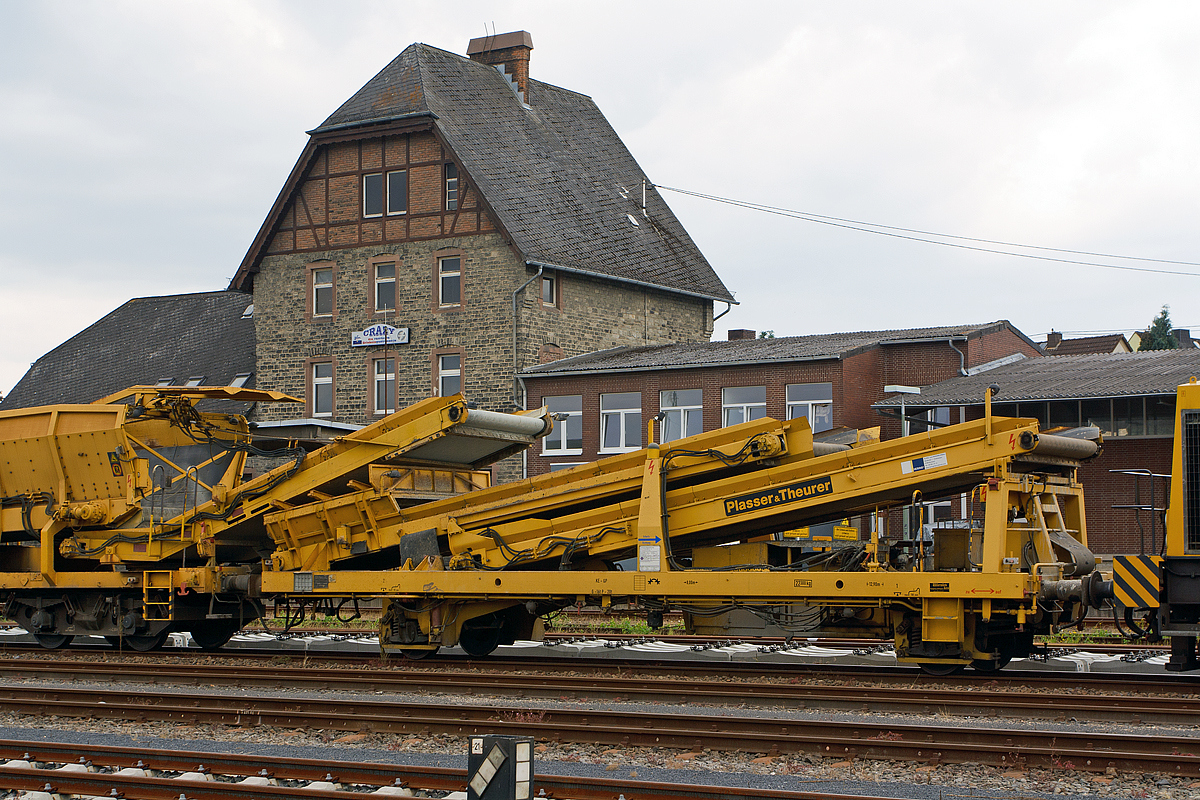 
Plasser & Theurer Beladestation BLS 2000 (Schweres Nebenfahrzeug Nr. 97 19 26 502 57-8) der Hering Bau, Burbach, abgestellt am 02.08.2014 im Bahnhof Sierhahn (Westerwald). 

Um Schüttgüter mittels Erdbaugeräten (Bagger etc.) in MFS-Einheiten fördern zu können, ist die Beladestation entwickelt worden. Sie besteht aus Schottertrichter, breitem Kettenförderband und hydraulisch ein- und ausfahrbarem Übergabeförderband mit Schwenkeinrichtung für die Arbeit im Gleisbogen. 
Die BLS 2000 ist ein zweiachsiges, gleisfahrbares Gerät. Zur leichteren Beladung kann der Schottertrichter während der Arbeit hydraulisch abgesenkt werden. 

Technische Daten:
Achsanzahl: 2
Eigengewicht:  22.300 kg
Länge über Puffer: 12.900 mm
Achsabstand: 8.000 mm
Höchstgeschwindigkeit: 100 km
