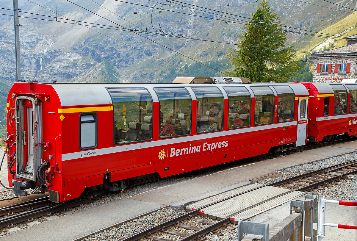RhB Ap 1292 ein 1.Klasse Bernina-Express Panoramawagen der 1. Serie am 06.09.2021 im Zugverband des Bernina-Express (BEX) nach St.Moritz beim Halt in Alp Gr�m.

Die Rh�tische Bahn verf�gt �ber einen variantenreichen Wagenpark, zu dem etwa 380 Personenwagen geh�ren. Die Vielzahl der unterschiedlichen Fahrzeugtypen macht den besonderen Reiz des Rollmaterialbestandes der RhB aus.

Nachdem bereits 1986 die ersten Panoramawagen der Furka-Oberalpbahn (FO) auf dem Netz der RhB zum Einsatz kamen, sah man 1998 bei der RhB den Bedarf, neue Personenwagen zur Erh�hung des Fahrgastkomforts anzuschaffen. Nun sollte auch f�r den Bernina-Express (BEX) ein Qualit�tsschub erfolgen. Die Wahl fiel auf moderne Panoramawagen aus dem Baukastensystem der Firma Stadler (ehemalige Schindler Altenrhein). Die RhB bestellte acht Niederflur-Steuerwagen f�r den Verkehr ins Unterengadin und 10 Panoramawagen f�r den Bernina-Express. Neben den Entw�rfen der PA-90-Wagen, die mit der �bernahme des Werks Altenrhein von Schindler zu Stadler gewechselt hatten, griff Stadler auf seine Arbeiten zu den GTW-Steuerwagen zur�ck. So erhielten alle 18 Fahrzeuge eine gemeinsame Basis. Als Drehgestell wurde jedoch weiter der Typ SIG 90 eingebaut. Wegen des Einsatzes �ber die Bernina mussten die Wagen verk�rzt werden. Gegen�ber dem Breda-Wagen mussten 3226 mm eingespart werden. Beim Sitzteiler wurden keine Kompromisse gemacht, er betr�gt 2.054 mm in der 1. Klasse und 1.782 mm in der 2. Klasse (gleiche Ma�e wie beim PA-90), hingegen wurde, entsprechend der v�llig anderen Kundschaft, weitgehend auf Gep�ckablagen verzichtet und die Vorr�ume verk�rzt. So konnten dennoch 34 Sitze in erster und 46 Sitze in zweiter Klasse untergebracht werden. Erstmals wurden in einem Panoramawagen nur noch drei Sitze nebeneinander in erster Klasse angeordnet. Auch hier besteht der Wagenkasten aus Aluminium. 

Um den Bernina-Express einheitlich mit Panoramawagen ausr�sten zu k�nnen und zudem ein Angebot S�d-Nord f�r italienische G�ste aus dem Raum Mailand nach St. Moritz anbieten zu k�nnen, wurden 2006–2007 noch einmal 16 gleiche Wagen (Api 1301–1306, Bps 2512–2515, Bp 2521–2526) beschafft. Diese erhielten nun allerdings luftgefederte Stadler-Drehgestelle und eine (vakuumgesteuerte) Druckluftbremse, letztere wurde auch bei den bestehenden Wagen nachger�stet. Zudem wurde im Erstklasswagen eine rollstuhlg�ngige Toilette eingebaut. Da inzwischen das Rauchen in Schweizer Z�gen generell verboten wurde, konnte auch auf eine Trennwand f�r ein Raucherabteil verzichtet werden, bei den bisherigen Wagen wurde diese entfernt.

Mit den nun 26 Wagen werden vier Z�ge mit je zwei Wagen erster und vier Wagen zweiter Klasse gebildet, mit denen insgesamt f�nf Zugspaare gefahren werden. Seit Inbetriebnahme der Allegras wird der Hauptzug Chur–Tirano und zur�ck mit sieben Wagen gefahren.

�u�erlich unterscheiden sich die Panoramawagen 1. Klasse von ihren Schwesterfahrzeugen der 2. Klasse durch eine andere Fenstereinteilung. Statt sieben Panoramafenstern haben die Fahrzeuge der 1. Klasse sechs gr��ere Fenster pro L�ngsseite (bei den Wagen der 2. Serie sind es nur 5).

Auch bei der Inneneinrichtung gibt es nat�rlich Unterschiede: Die Sitze der 1. Klasse sind mit echtem Leder �berzogen und etwa 3 cm breiter. Daher weisen die Fahrzeuge eine 2+1 Bestuhlung auf, wohingegen die Panoramawagen der 2. Klasse mit einer 2+2 Bestuhlung ausger�stet sind. Dar�ber hinaus wurde in den Wagen der 1. Klasse ein eleganter Teppichboden verlegt.

TECHNISCHE DATEN Ap-Wagen:
Bezeichnung und Betriebsnummern: Ap 1291 bis Ap 1293
Baujahr: 2000
Hersteller: Stadler
Spurweite: 1.000 mm
Anzahl der Achsen: 4
Drehgestelle: Stadler (Typ SIG 90)
L�nge �ber Kupplung: 16.450 mm
Eigengewicht: 19.100 kg
zul. H�chstgeschwindigkeit:100 km/h
Sitzpl�tze: 34
Lauff�hig: StN, BB, MGB
Besonderheiten: Klimaanlage, geschlossenes WC und Panoramafenster mit elektrisch bet�tigten Rollos
