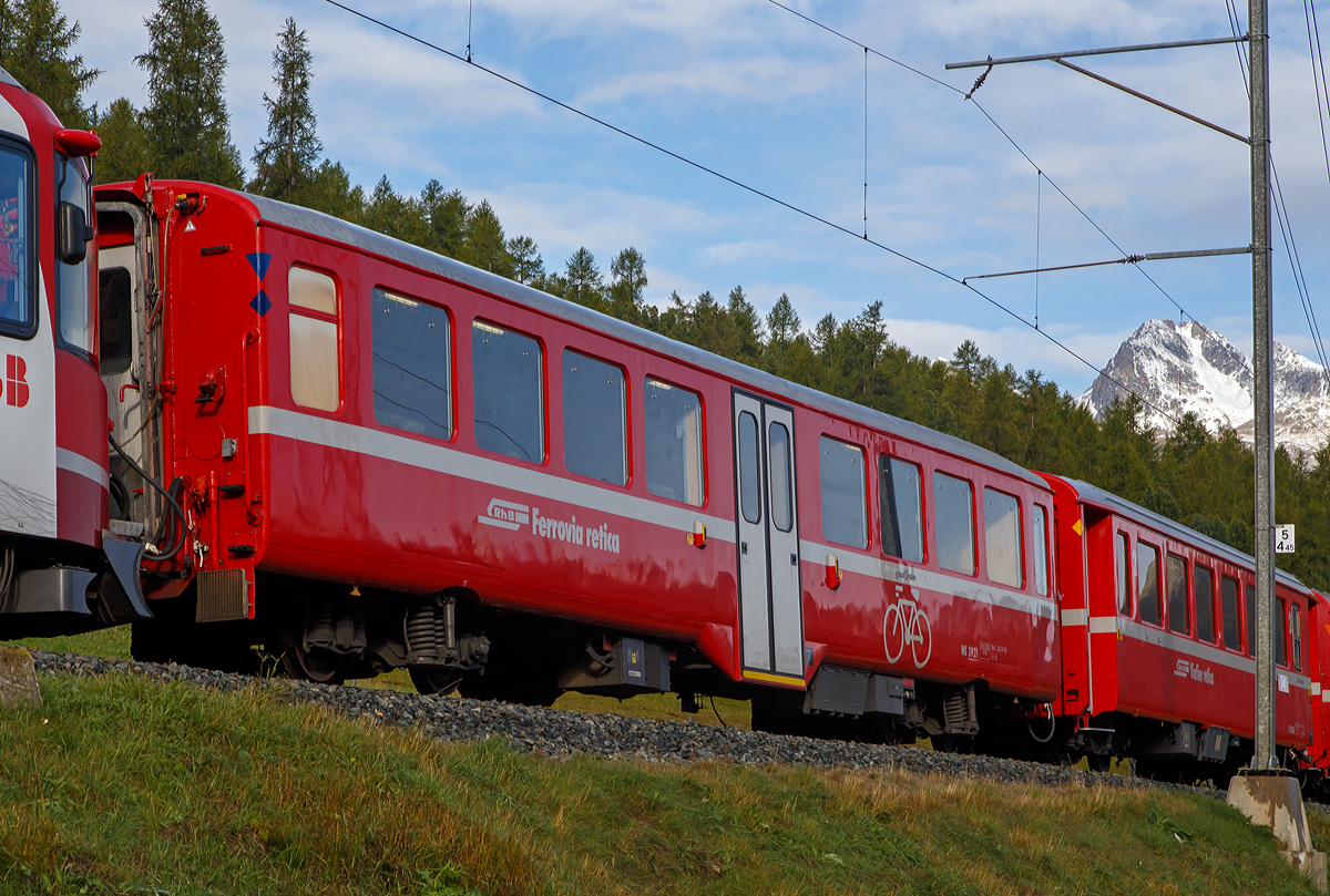 RhB Velowagen Bernina WS 3921, ex B 2332,  am 13.09.2017 in Pontresina im Zugverbund. Velo ist die Schweizer Bezeichnung f�r Fahrrad.

Bed�rfnis Velotransport auf der Berninastrecke
Im Gebiet Engadin und Bernina wird der Velosport durch die  Tourismus-Organisationen sehr stark gef�rdert. Dies hat auch  zur Folge, dass der Velotransport per Bahn zugenommen hat. Der bestehende Stauraum im Gep�ckabteil hat oft nicht mehr  gen�gt. F�r die Stammnetz-Strecken wurden in den Jahren 2001–2008 vier Velowagen (WS 3911–3914) aus Mittelwagen hergerichtet. Diese Wagen sind zu lang f�r die Berninastrecke. Es wurden verschiedene L�sungen untersucht, z.B. der Umbau  von Bernina-Wagen oder das K�rzen der StN-Wagen um zwei  Meter.  Auf Bernina-Wagen kann jedoch nicht verzichtet werden, da sonst das Sitzplatzangebot reduziert w�rde. Die K�rzung von Stammnetz-Wagen um zwei Meter ist auch sehr  aufwendig und unwirtschaftlich. Nach langem Suchen wurde eine Wagenserie gefunden, die geeignete Wagenkastenabmessungen f�r die Berninastrecke aufweist. Mit einem vom R-ES entwickelten Profilberechnungsprogramm wurde ermittelt, um wie viel der Drehgestell-Abstand ge�ndert werden muss, damit die Wagen auch auf der Berninastrecke eingesetzt werden k�nnen. 

Umbau zu Velowagen Bernina
An den beiden Wagen B 2332–2333 wurden die Schemeltr�ger  (Drehgestell-Quertr�ger)  herausgetrennt  und je Seite um 550 mm n�her wieder eingeschwei�t. Somit wurde der  Drehgestellabstand von 12.390 mm auf 11.290 mm reduziert.  Der Innenraum wurde genau gleich umgebaut wie die vorhandenen Velowagen WS 3911–3914.

Die beiden Velowagen WS 3921–3922 k�nnen im Sommer auf  dem gesamten RhB-Streckennetz eingesetzt werden, sind jedoch vorzugsweise auf der Berninalinie im Einsatz. Im Winter k�nnen die beiden Wagen in den Schlittenz�gen mit den vier anderen Velowagen eingesetzt werden. Die beiden Velowagen  wurden mit der Mehrzugsteuerung ausger�stet und sind somit auch pendelzugf�hig. 

Die beiden Velowagen besitzen jeweils 52 Klappsitzpl�tze und 48 Velohaken.
