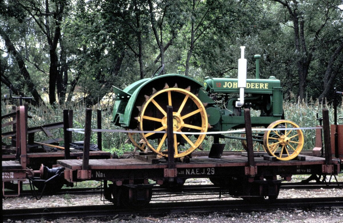 Schmalspur Flachwagen, beladen mit einem Traktor John Deere bei der Östra Södermanlands Järnväg in Mariefred am 07.08.1994.