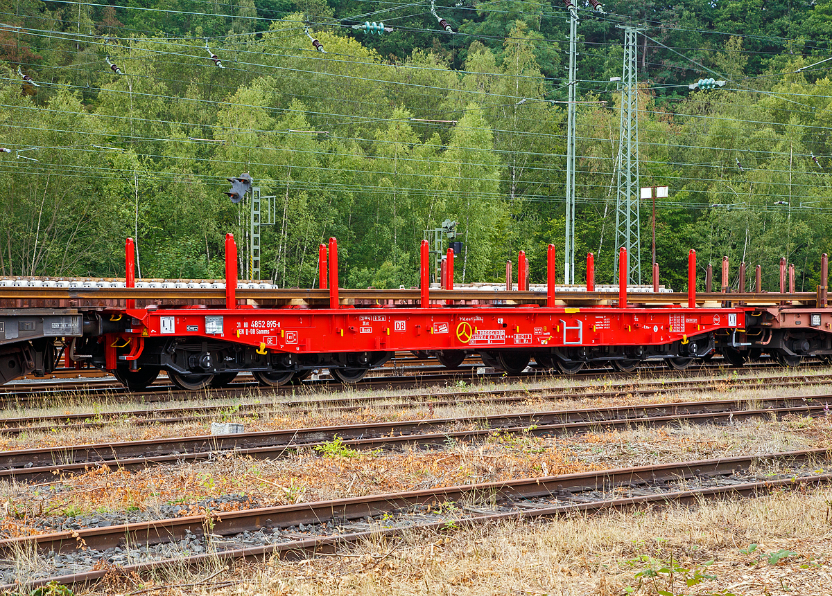 Sechsachsiger Drehgestell-Flachwagen, mit Rungen, Stirnwandklappen und klappbaren Ladeschwellen, jedoch ohne Seitenwandklappen, 31 80 4852 895-6 D-DB, der Gattung Samms 489.1, der DB Cargo AG, abgestellt am 09.08.2019 im Zugverband, beladen mit Langschienen, am 09.08.2019 im Rbf Betzdorf (Sieg).

Der Wagen war sehr neu, er wurde 2019 von Tatravagonka a.s. in Poprad (Slowakei) unter der Fabriknummer 036 gebaut. Zusammen mit Stahlkunden entwickelt die DB Schenker im Jahre 2007 einen neuen Flachwagen, der auf die Bedürfnisse der Branche noch besser eingeht. Gebaut wurden sie von dem slowakischen Hersteller Tatravagonka Poprad, die DB Cargo hatte 225 Wagen bestellt.

Der Wagen dient mit aufgeklappten Ladeschwellen zur Beförderung von schweren Walzprofilen und anderen sperrigen Gütern. Mit eingeklappten Ladeschwellen, also mit ebener Ladeebene, eignet er sich auch zum Transport schwerer Kettenfahrzeuge. Für das Be- und Entladen solcher Fahrzeuge sind befahrbare Stirnwandklappen vorhanden. Die Wagenbrücke ist eine in Rahmenbauweise ausgeführte Schweißkonstruktion, deren Hauptbauteile aus S355J2 (St 52) bestehen. Die Hauptbelastungen werden von den äußeren Langträgern aufgenommen. Das Kopfstück und Untergestell sind so ausgebildet, dass später ohne große Änderungen die AK eingebaut werden kann. Der Fußboden besteht aus Kiefernbohlen mit den Abmessungen 70 x 200 mm; er kann eine Radlast von 5,0 t aufnehmen. Im Fußboden sind 6 geteilte klappbare Ladeschwellen eingebaut, ebenso 6 Zurrpunkte je Längsseite. An den Außenlangträgern sind 26 Bindeösen angebracht.

Das Fahrzeug hat auf jeder Längsseite 6 Einsteckrungen und 6 zusätzliche Rungenschächte, wodurch eine variable Platzierung der Rungen ermöglicht wird (anders als bei den Vorgänger-Modellen). An jeder Stirnseite gibt es je 2 versenkbare Rungen (Fallrungen). Die Stirnwände sind umklappbar.

Die Tragfähigkeit konnte im Vergleich zu anderen Wagen der Bauart Samms auf 104 Tonnen gesteigert werden, weshalb bis zu 20 Prozent Wagenresourcen eingespart und die Transportkette optimiert werden kann. Durch den Einsatz der Kunststoff-Bremssohle (Cosind 810) fährt der Wagen lärmreduziert.

TECHNISCHE DATEN:
Gattung: Samms 489.1 (Gattungskennzahl 4852 / 4858)
Spurweite: 1.435 mm (Normalspur)
Länge über Puffer: 16.400 mm
Drehzapfenabstand: 9.150 mm
Radsatzstand in den Drehgestellen: 2 x 1.700 mm = 3.400 mm
Raddurchmesser: 920 mm (neu)
Drehgestell-Typ: BA 714.3
Ladelänge: 15.000 mm
Ladebreite: 2.630 mm (zwischen den Rungen)
Fußbodenhöhe über SO: 1.300 mm
Ladefläche: 46 m²
Eigengewicht: 31.000 kg
Zuladung bei Lastgrenze S: 74,0 t (ab Streckenklasse D2)
Zuladung auf DB Netz bei Streckenklasse CE/D: 89 t (max.100 km/h)
Max. Zuladung: 104 t
Max. Geschwindigkeit: 100 km/h (beladen) / 120 km/h (leer)
Kleinster Gleisbogenhalbmesser: 75 m
Bauart der Bremse: KE-GP-A (K) max. 88 t
Bremssohle: Cosid 810
Handbremse: Ja
Internationale Verwendungsfähigkeit: TEN-GE
