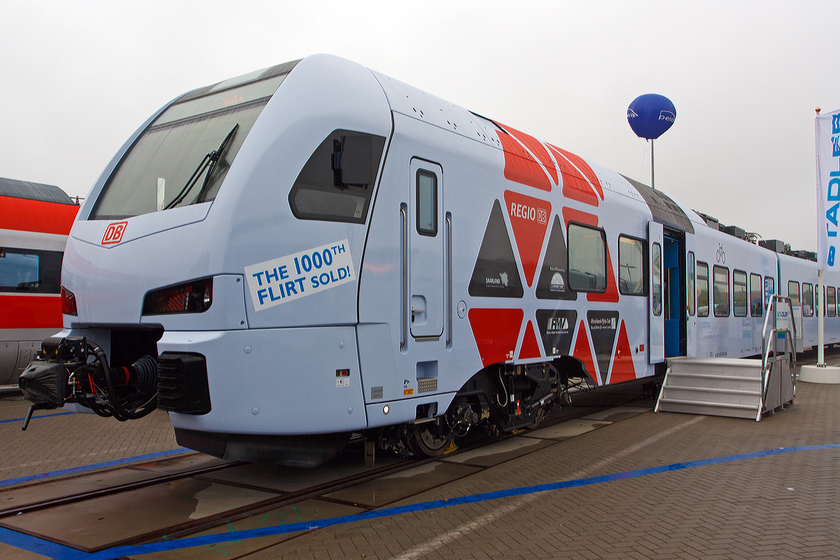 Stadler Pankow pr�sentiert den 1. FLIRT der 3. Generation f�r die DB Regio AG, auf der InnoTrans 2014 (hier 26.09.2014) und bald f�hrt er auf der Saar- und Moselstrecke.  

Es ist der f�nfteilige Stadler FLIRT 94 80 0429 113-4 D-DB / 94 80 0429 613-3 D-DB. Dabei handelt es sich um das erste Fahrzeug der Serie f�r die DB Regio AG. Insgesamt wurden 28 Fahrzeuge des Typs in Auftrag gegeben. Die Fahrzeuge werden ab Dezember 2014 das R�ckgrat des neuen, landesweiten RE-Netzes in Rheinland-Pfalz bilden.

Die neuen Triebz�ge sind erstmals nicht im typischen „DB Rot“ der Deutschen Bahn gestaltet, sondern in der Grundfarbe wei� (wobei ein richtiges wei� ist es nicht) lackiert und mit grauen und roten Elementen an den Triebfahrzeugk�pfen versehen. Des Weiteren ist die Inneneinrichtung abweichend vom bisherigen DB Design gestaltet. Die �u�erliche Farbgestaltung gef�llt mir pers�nlich nicht, dagegen aber die Innenraumgestaltung.
Eine technische Besonderheit ist die Kuppelbarkeit der FLIRT3-Z�ge mit den doppelst�ckigen KISS-Z�gen der CFL (Luxemburgische Staatsbahn). Erstmals werden Triebz�ge unterschiedlichen Typs von zwei europ�ischen Staatsbahnen aneinandergekoppelt fahren, dies auf der Moselstecke (der RE 1 von Saarbr�cken und der CFL-KISS von Luxemburg werden in Trier aneinandergekoppelt und fahren dann gemeinsam nach Koblenz. In der Gegenrichtung werden sie in Trier gefl�gelt werden. 

„Wir sind stolz darauf, dass zwei Staatsbahnen gekoppelt mit zwei unterschiedlichen Produkten aus unserem Hause zuk�nftig die Strecken Trier-Koblenz befahren werden“, sagt Michael Daum, Gesch�ftsf�hrer der Stadler Pankow GmbH. „Der FLIRT der 3. Generation ist ein hochmodernes Schienenfahrzeug und bietet viel Komfort. Erstmals finden wir in der Ausf�hrung f�r die DB Regio einen Mittelwagen ohne T�r, welcher den Fahrg�sten einen komfortablen Ruhebereich erm�glicht. Die Zulassung f�r die Flirt�-Doppeltraktion liegt bereits vor.“

Die f�nfteiligen Fahrzeuge sind in den Vis-�-vis-Sitzbereichen mit gro�en Tischen ausgestattet. Fahrgastbereiche und Fahrerraum sind klimatisiert. Eines der beiden behindertengerechten WCs ist auch f�r Elektrorollst�hle geeignet, der Einstieg in den Zug ist barrierefrei. Jedes Fahrzeug bietet 249 Sitzpl�tze in der zweiten und 21 Sitzpl�tze in der ersten Klasse. Der FLIRT verf�gt �ber eine hohe Antriebsleistung und erreicht eine maximale Geschwindigkeit von 160 km/h.

Technische Merkmale:
Helle freundliche Fahrgastr�ume mit hohem Niederfluranteil
2 Rollstuhlgerechte WC-Kabine (1x auch f�r Elektrorollst�hle)
Leichtbauweise aus Aluminium
Redundante Antriebsausr�stung bestehend aus 2 Antriebsstr�ngen mit je einem Transformator, IGBT Stromrichter und 2 Asynchronfahrmotoren
Auslegung des Wagenkastens auf eine L�ngsdruckkraft von 1.500 kN
Luftgefederte Fahrwerke sorgen f�r die erforderliche Laufruhe
Breite, zweifl�gelige Schwenkschiebet�ren
Zwei elektrische �bereinander angeordnete Schiebetritte pro Einstiegst�r
Gro�e Tische in den vis-�-vis-Sitzbereichen

TECHNISCHE DATEN:
Spurweite: 1.435 mm (Normalspur)
Achsanordnung: Bo‘2‘2‘2‘2‘Bo
L�nge �ber Kupplung: 90.800 mm
Fahrzeugbreite: 2.880 mm
Fahrzeugh�he: 4.120 mm
Fu�bodenh�he Niederflur: 780 mm
Fu�bodenh�he Hochflur: 1.200 mm
Einstiegsbreite: 1.300 mm je T�r
Anzahl der T�ren ja Fahrzeugl�ngsseite: 4
Einstiegsh�he: 780 mm
L�ngsdruckkraft:1.500 kN
Sitzpl�tze: 271 (1. Klasse 23 / 2. Klasse 248)
Stehpl�tze (4 Pers./m�): 280
Dienstgewicht: ca. 156 t
Motordrehgestell-Achsabstand: 2.500 mm
Laufdrehgestell-Achsabstand: 2.700 mm
Triebraddurchmesser: 920 mm
Laufraddurchmesser: 760 mm
Nennleistung: 4 x 500 kW = 2.000 kW
Max. Leistung (kurzzeitig): 4 � 750 kW = 3.000 kW
Anfahrzugkraft: 175 kN
H�chstgeschwindigkeit: 160 km/h
mittlere Anfahrbeschleunigung bis 50 km/h: 0,91 m/s�
Kupplung: Scharfenbergkupplung (Schaku) Typ 10
Besonderheiten: Mehrfachtraktionsf�hig und Kuppelf�hig mit KISS

Quellen: Stadler Rail
Berichtigung/Update: 02.09.2025

Pers�nliche Anmerkung:
Die �u�erliche Gestaltung, insbesondere die Farbgestaltung ist f�r mich gew�hnungsbed�rftig. Die Innenraumgestaltung (siehe nachfolgende Bilder) ist f�r mich gelungen und ich denke auch bequemer als so manch anderer Triebzug. Ich hoffe sehr dass sich die Fahrzeiten von Koblenz nach Trier, Luxemburg und Saarbr�cken reduzieren werden und der Takt stimmt, dass diese Z�ge eine echte Alternative zu den PKW darstellen. Leider sind die n�chsten Preiserh�hungen schon wieder angek�ndigt, man hat es hier leider noch nicht verstanden das Preiserh�hungen das Gegenteil bewirken. Bei einem g�nstigeren Preis steigen mehr Menschen von der Stra�e auf die Schiene um, und so werden die Zuge ausgelastet und die Kassen voller. Frei nach dem Sprichwort, „Vieles Kleines bringt ein gro�es Mehr“, wann wird man das hier verstehen.

