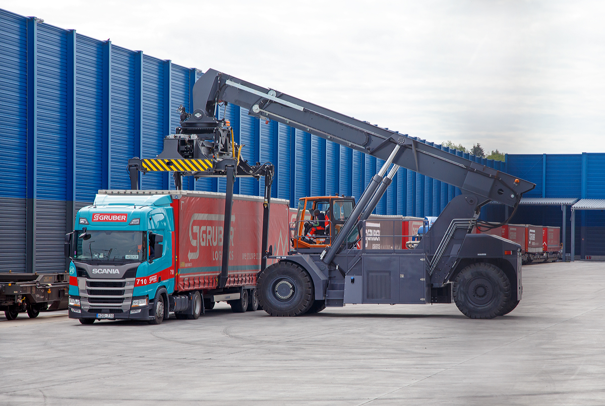 
Südwestfalen Container-Terminal GmbH (SWCT), Kreuztal Ubf, den 31.05.2019:
Die Entladung der Gelenk-Taschenwagen der Gattung Sdggmrs (Typ T3000e).  Die Sattelauflieger (Sattelanhängern) werden nach und nach mittels Reachstacker bzw. Greifstapler aus den Gelenk-Taschenwagen gehoben und sofort an die Sattelzugmaschine angehangen.
