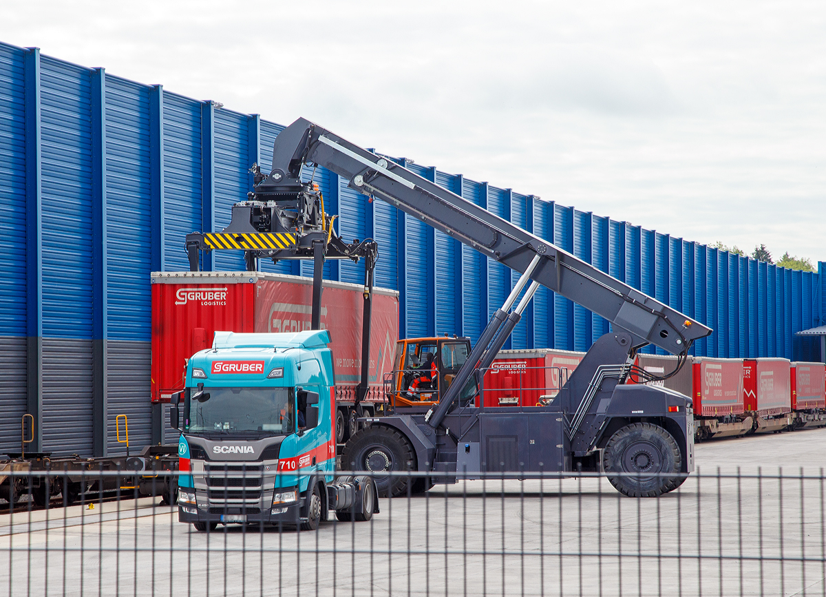 
Südwestfalen Container-Terminal GmbH (SWCT), Kreuztal Ubf, den 31.05.2019:
Die Entladung der Gelenk-Taschenwagen der Gattung Sdggmrs (Typ T3000e).  Die Sattelauflieger (Sattelanhängern) werden nach und nach mittels Reachstacker bzw. Greifstapler aus den Gelenk-Taschenwagen gehoben und sofort an die Sattelzugmaschine angehangen.
