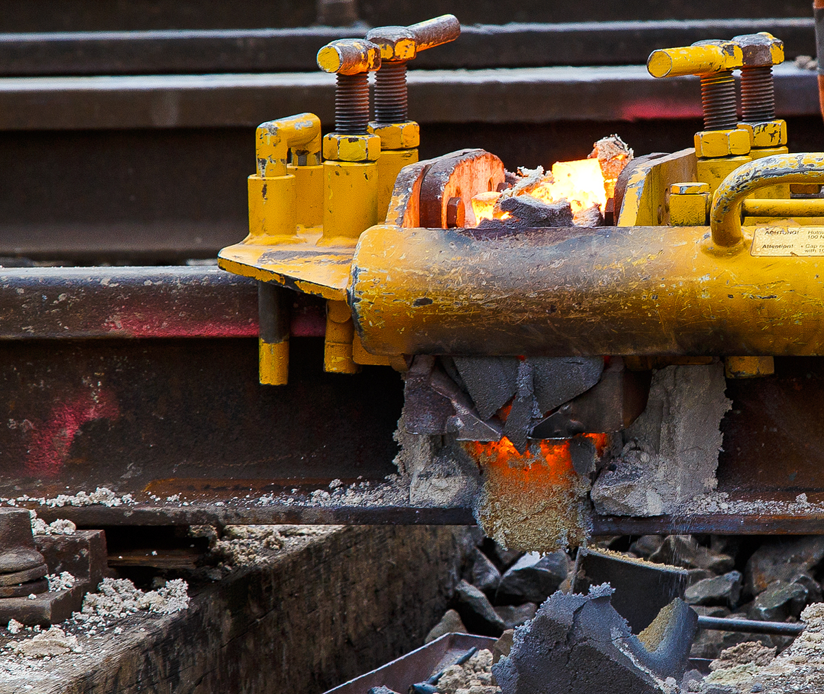 
Thermitschweißen am 31.10.2020 an der Hellertalbahn (KBS 462 / DB-Streckennummer 2651) hier Gleis 1 vom Bahnhof Herdorf.

Bild 7 – Nachdem der Thermit­Stahl erstarrt ist, werden die Schweißgutüberstände mittels Hydraulischem Abschergerät abgearbeitet. 