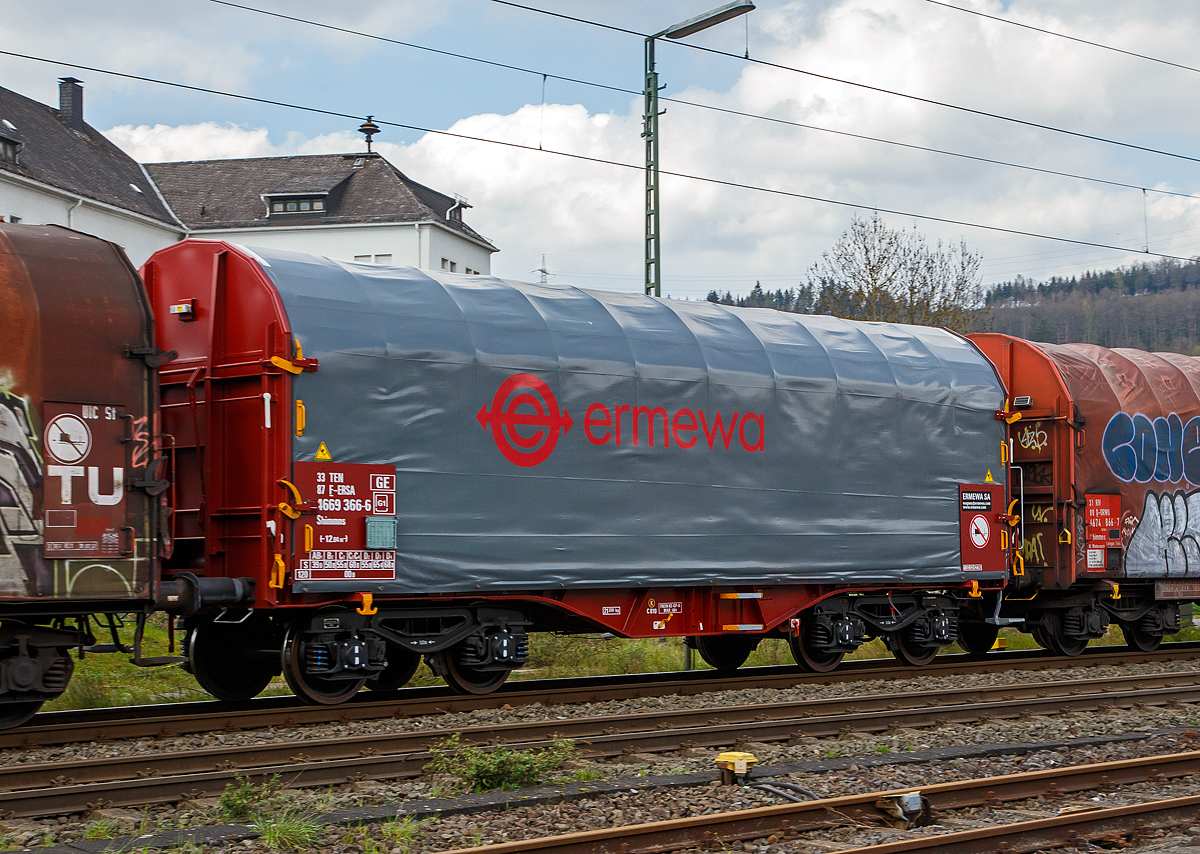 Vierachsiger Drehgestell-Flachwagen mit verschiebbarem Planenverdeck und Lademulden f�r Coiltransporte, 33 874669 366-6 F-ERSA der Gattung Shimmns, des Wagonvermieters Ermewa Holding SA, am 14.04.2022 im Zugverband bei einer Zugdurchfahrt in Niederschelden.