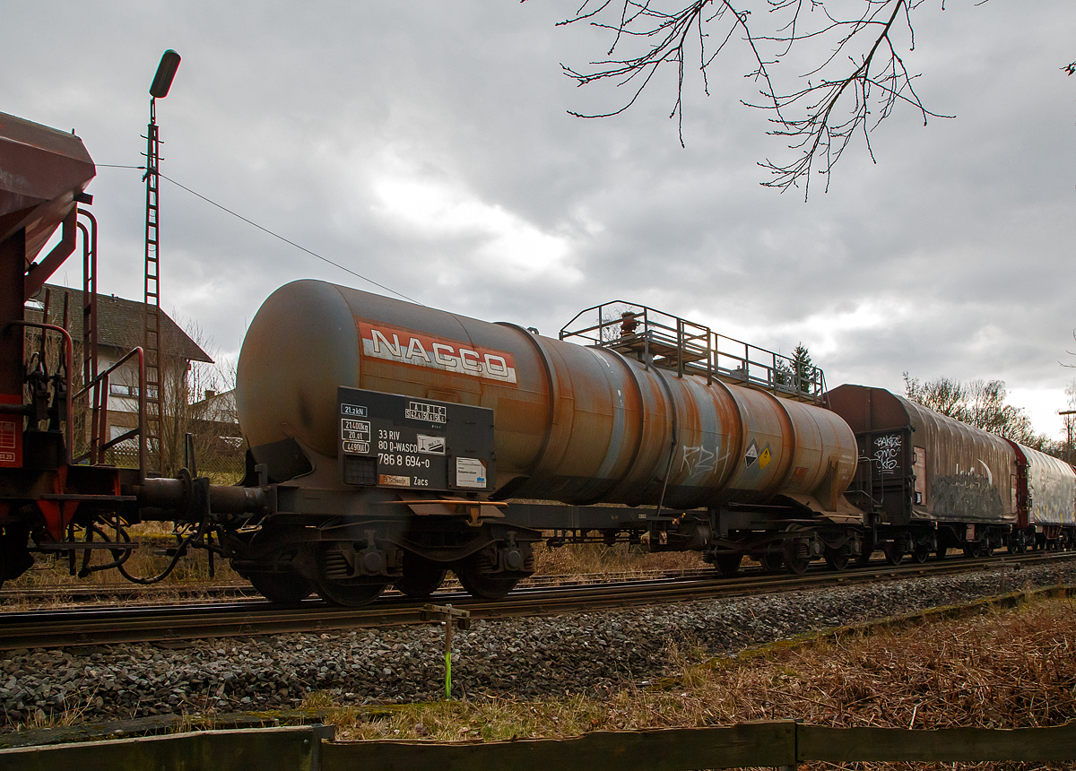 Vierachsiger-Drehgestell Kesselwagen für Salpetersäure (>98%), der Gattung Zacs, registriert als 33 80 7868 694-0 D-WASCO der WASCOSA AG, die einen Teil der NACCO Flotte übernommen hat, am 15.02.2022 in Herdorf, im Zugverband eines Übergabezuges der KSW.

Die Gefahrguttafel (885/2031) zeigt es auch noch an: (oben) Gefahrgutnummer 885 = stark ätzender Stoff / (unten) UN-Nummer 2031 = Salpetersäure, andere als rotrauchend, mit mehr als 70 % Säurebrandfördernd. Hier sogar (laut Anschrift) größer 97 %.
Die reine Säure ist farblos und hat einen scharf stechenden Geruch. Sie wird unteranderem zur Herstellung von Sprengstoffen verwendet, was hier der Fall ist.

TECHNISCHE DATEN:
Gattung: Zacs
Spurweite: 1.435 mm
Länge über Puffer : 14.240 mm
Drehzapfenabstand: 9.200 mm
Achsabstand im Drehgestell: 1.800 mm
Höchstgeschwindigkeit: 100 km/h 
Eigengewicht: 21.400 kg
Nutzlast: 58,6 t ab Streckenklasse C
Gesamtvolumen: 44.900 Liter
Prüfdruck: 4 bar
Zulässiger Betriebsüberdruck: 3 bar
Tankcode: L10DH
Behälterwerkstoff : Edelstahl
Bremse: KG-GP
Intern. Verwendungsfähigkeit: RIV