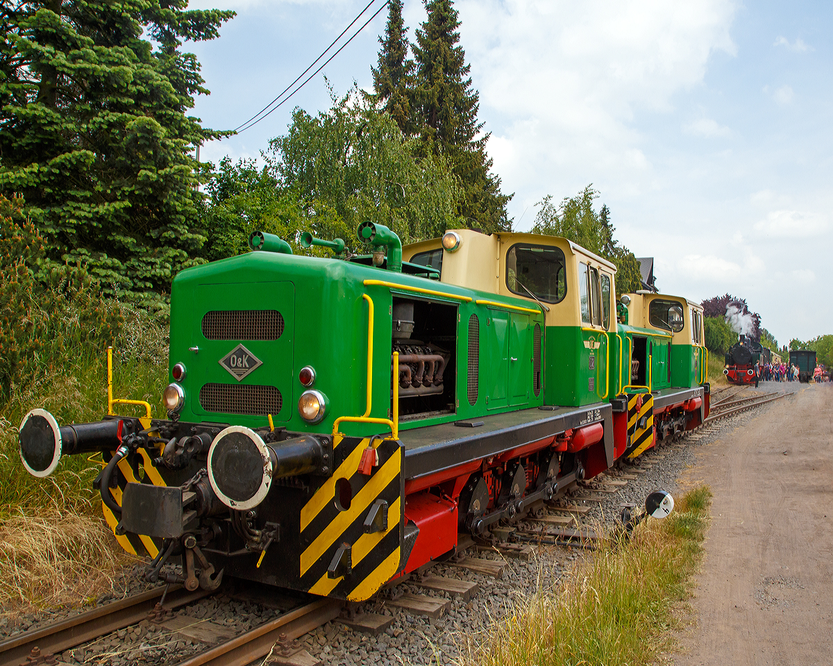 
Wegen der folgenden 5,5 km langen 50 ‰ Steilstrecke ist für die Malletdampflok 11sm in Oberzissen schluss, so wird hier nun umgespannt....

Nachdem die 11sm umgesetzt hat, fahren nun die Lok D2 und D1 der Brohltalbahn an den Zug heran, um diesen an den Haken zu nehmen und ihn weiter nach Engeln zu ziehen. 

Auffällig sind auch die, eigentlich für Schmalspurloks unüblichen Puffer. Die Brohltalbahn hat im Umladebahnhof Brohl ein Dreischienengleis (Meterspur und Normalspur (1.435 mm)), so können die Loks auch Normalspur-Wagons dort verschieben.
Die beiden baugleichen 1.000 mm Dieselloks wurden 1965 von O&K in Dortmund gebaut, die D1 unter Fabriknummer 26528 und die D 2 unter Fabriknummer 26529. 

TECHNISCHE DATEN:
Typ: O&K MV 10 S
Achsformel:  C
Spurweite:  1.000 mm
Länge über Puffer:  7.140 mm 
Gesamtachsabstand: 1.900 mm (2 x 950 mm)
Breite: 2.500 mm
Höhe über Dachscheitel: 3.050 mm
Dienstgewicht: 32 t 
Höchstgeschwindigkeit: 28 km/h
Raddurchmesser: 750 mm
Motor: Deutz
Dauerleistung: 300 PS
Getriebe: Voith 
Bremse: KE-GPmZ , Kraftbremse und Vakumbremse