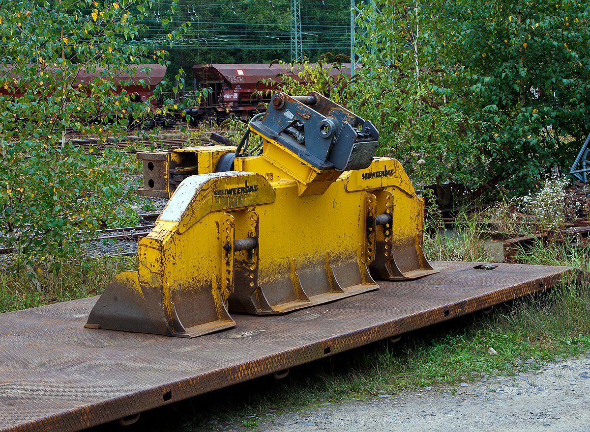 WINDHOFF Schwellenwechselgerät APE (HSW) der Schweerbau, zum Anbau an einen Zweiwege-Bagger, abgestellt am 20.09.2021 beim Bahnhof Betzdorf (Sieg).

Das Anbaugerät wurde 2017 von der WINDHOFF 
Gleisbautechnik GmbH (Rheine) unter der Fabriknummer APE20172113 gebaut.

Das hydraulische Schwellenwechselgerät HSW ist ein Multifunktionsaggregat für den Aus- und Einbau des Gleisschotterbettes sowie für das Wechseln von Holz- und Betonschwellen. Die Aufnahme des Schwellenwechselgerätes sowie die hydraulische Energieversorgung erfolgt vom Zweiwege-Bagger.

Der Aus- und Einbau der Schwellen erfolgt durch die angebaute hydraulische, 360° endlos drehbare Schwellenzange angebaute. Die Positionierung und Konstruktion dieser Zange wurde so gewählt, dass ein sicherer und schonender Aus- und Einbau aller gängigen Holz- und Betonschwellen gewährleistet ist. Es ist kein Wechseln der Zange erforderlich, auch bei unterschiedlichen Schwellenarten.

Um eine hohe Effektivität des Schwellenwechselgerätes zu erreichen, wurde das maximale Volumen bei den fest montierten Schaufelsegmenten gewählt.
Die Grabtiefe des Schwellenwechselgerätes HSW ist durch zwei verstellbare Rollen (die dann auf dem Gleis aufliegen) variabel und somit individuell einstellbar.

Technische Daten:
Gewicht: 1.400 kg
Breite: 2.750 mm
Betriebsdruck: 250 bar
Spurweite: 1.435 mm  

