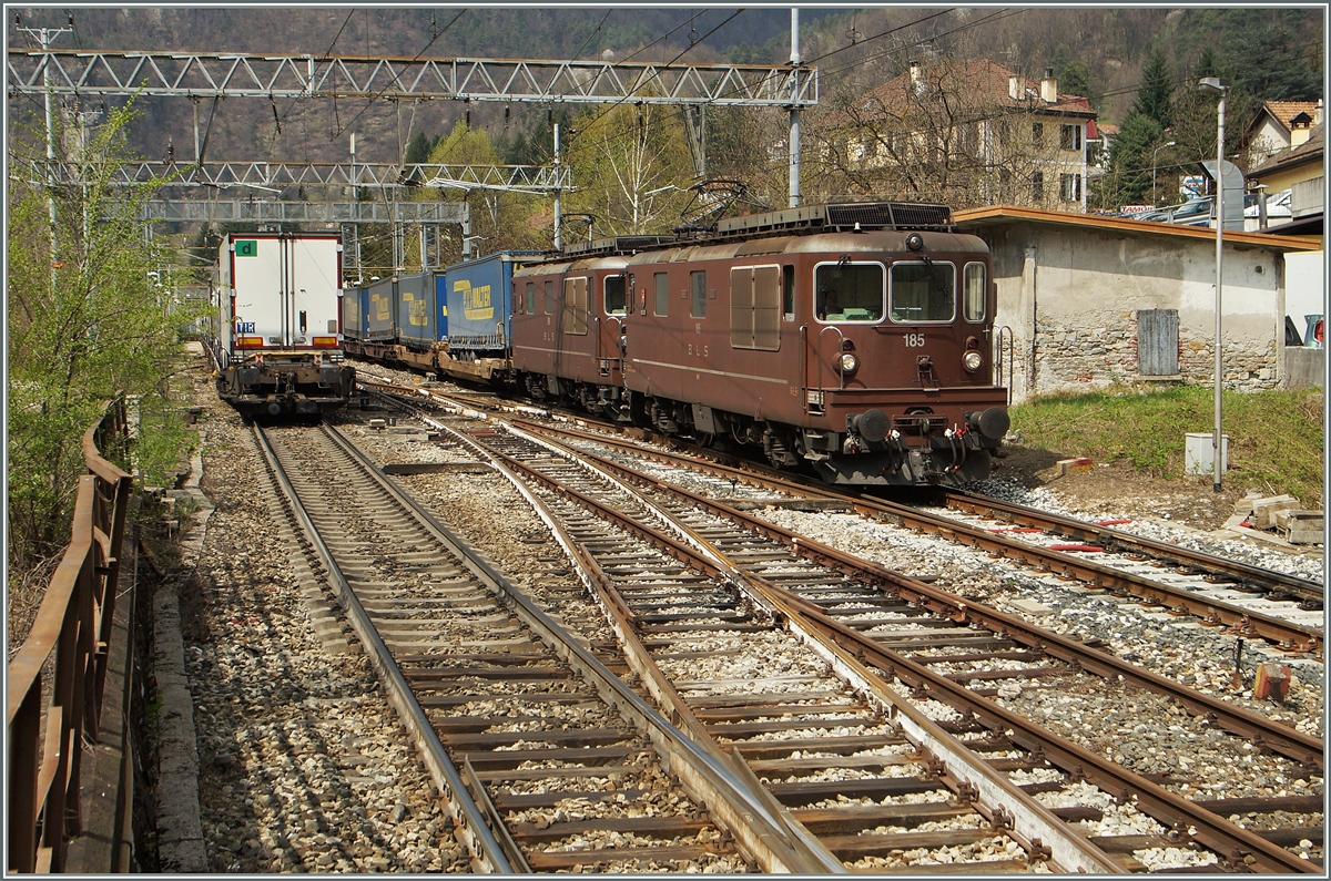 Zwei BLS Re 4/4 sind mit einem Containergüterzug bei Varzo Richtung Süden unterwegs, während ein RoLa Zug auf  Feie Fahrt  Richtung Norden wartet.
11. April 2015