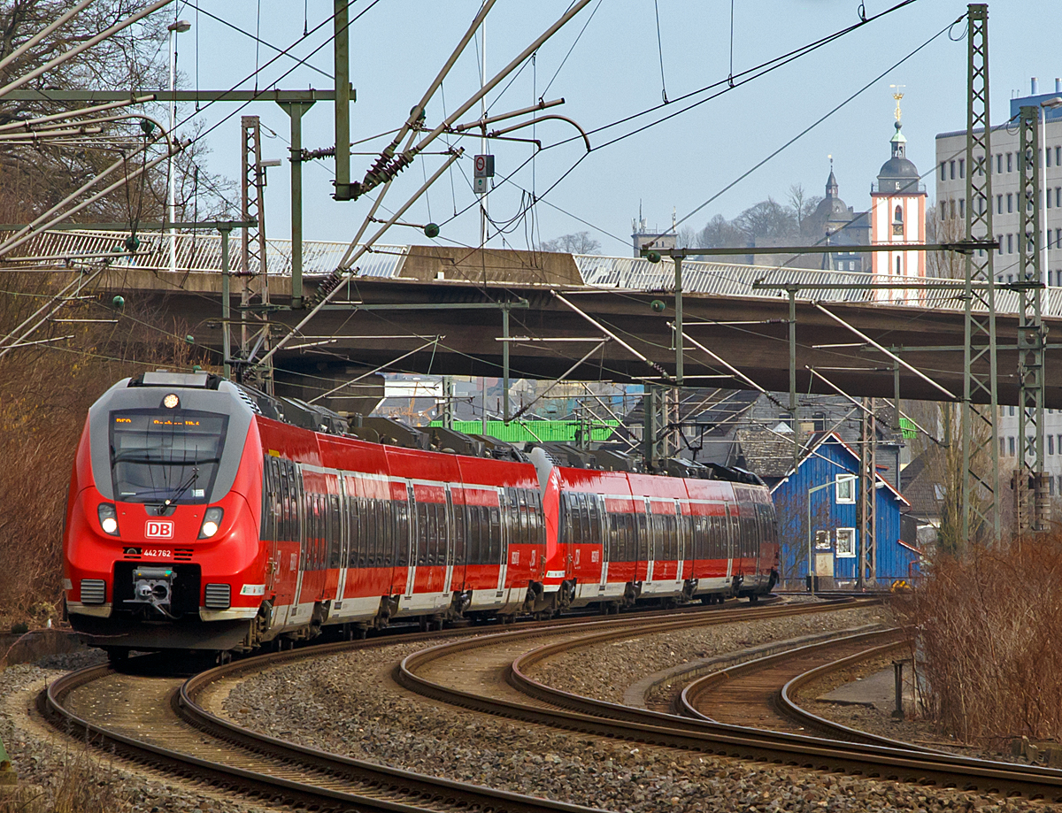 
Zwei gekoppelte 4-teilige Bombardier Talent 2 haben gerade (am 14.02.2015), als RE 9 (rsx - Rhein-Sieg-Express) Siegen - Köln - Aachen, den Hbf Siegen in Richtung Köln verlassen. 

Gut zu erkennen ist auch der (rot-weiße) Kirchturm der evangelischen Nikolaikirche, auf seiner Spitze befindet sich das Wahrzeichen der Stadt Siegen, das Krönchen. 

Das Krönchen ist ein Geschenk von Fürst Johann Moritz zu Nassau-Siegen an die Stadt Siegen und ihre Bürger. Der Anlass für das Geschenk war die Erhebung von Johann Moritz in den Fürstenstand im Jahre 1652. Der Fürst ließ die Skulptur auf eigene Kosten anfertigen und seit 1658 ziert es die Spitze des Kirchturms. Von seiner Residenz dem Oberen Schloss (links vom Turm) konnte er darauf schauen.
