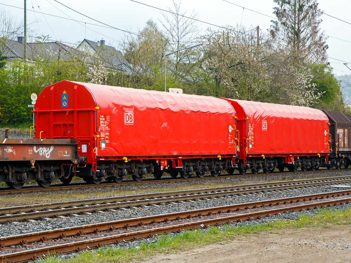 Zwei sechsachsige Drehgestell-Flachwagen mit verschiebbarem Planenverdeck und Lademulden f�r Coiltransporte, 31 80 4876 521-4 D-DB und 31 80 4876 708-7 D-DB, der Gattung Sahimms-tu 902, der DB Cargo am 13.04.2019 im Zugverband bei der Durchfahrt in Mudersbach/Sieg.

Der Wagen ist f�r die Bef�rderung von schweren witterungsempfindlichen Blechrollen bestimmt. Dieser Spezialwagen besitzt Stirnw�nde und sieben fest im Untergestell eingebaute Mulden. Die Wagenabdeckung erfolgt mit einer PVC-beschichteten Gewebeplane, die auf 11 Rohrrahmen aufliegt. �ber Laufwagen ist das Planendach in Wagenl�ngsrichtung verschiebbar. Die Verriegelung des Planendaches an den Stirnw�nden erfolgt �ber eine 4-Punkt-Zentralverriegelung, die sowohl vom Erdboden als auch von der Rampe aus bedient werden kann. Das Planendach l�sst sich an einem Wagenende so weit zusammenschieben, dass ca. 2/3 der Ladefl�che zur Beladung freigegeben wird. Zwischen den Spriegeln sind Hilfsspriegel so angeordnet, dass ein Einfallen der Plane beim Zusammenschieben um die H�lfte vermindert wird, um den notwendigen Freiraum f�r gr��ere Coildurchmesser zu gew�hrleisten. Der Wagen darf nur mit geschlossenem und verriegeltem Planendach verkehren.

Der Kennbuchstabe „tu“ bedeutet:  Mit  besonderer  Festlegeeinrichtung  zum  Sichern  geb�ndelter Schmalbandcoils  und  Auskleidung  der  Mulden  mit  gewebeverst�rkten Gummimatten.

TECHNISCHE DATEN:
Spurweite: 1.435 mm
Achsanzahl: 6 (in 2 Drehgestelle)
L�nge �ber Puffer: 15.000 mm
L�nge der Ladefl�che: 13.760 mm
Drehzapfenabstand: 8.000 mm
Achsabstand im Drehgestell: 2 x 1.700 mm
Eigengewicht: 32.300 kg
H�chstgeschwindigkeit:  100  km/h (beladen) / 120 km/h (leer)
Zuladung bei Lastgrenze S: 72,5 t (ab Streckenklasse D3) 
Max. Zuladung Streckenklasse CE bei max.100 km/h:  87,5 t 
Max. Tragf�higkeit des Wagens: 99,5 t
Kleinster Gleisbogenhalbmesser: 75 m
Bauart der Bremse: KE-GP
Intern. Verwendungsf�higkeit: RIV