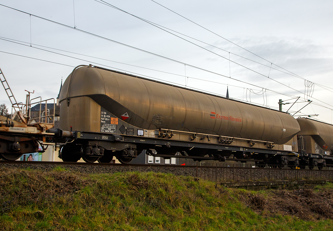 4-achsiger Drehgestell-Staubgutwagen (128 m³ Silowaggon) 33 56 9327 015-9 SK-EXSK, der Gattung Uacns 932, der Express Slovakia (Express Group, a.s.) aus Bratislava (Slowakei), am 22.02.2023 bei der Zugdurchfahrt in Kirchen (Sieg). Die Gefahrguttafel (Gefahrgutnummer 40/1361) aber auch die Aufschrift „Uholny Prach“ sagen aus, dass hier Kohlestaub (vermutlich Braunkohlestaub) transportiert wird.

TECHNISCHE DATEN:
Hersteller: Feldbinder Spezialfahrzeugwerke GmbH
Herstellerbezeichnung: Silowaggon BEUT 128.4-6/1 RID (Braunkohlestaub)
Gattung: Uacns 932
Spurweite: 1.435 mm
Länge über Puffer : 20.840 mm
Drehzapfenabstand: 15.800 mm
Achsabstand im Drehgestell: 1.800 mm
Höchstgeschwindigkeit: 100 km/h (120 km/h leer)
Radsatzlast : 22,50 t
Eigengewicht: 20.000 kg
Nutzlast: 70,0 t ab Streckenklasse D
Drehgestelle: Y25 Lsi(f)-FFB-K
Kleinster bef. Halbmesser: 75 m
Gesamtvolumen: 128 m³
Betriebsdruck: 2,50 bar / -0,05 bar
Prüfdruck: 3,25 bar
Tankcode: SGAN
Behälterwerkstoff : Aluminiumlegierung (AW-5186 / AW-5083)
Bremse: KE-GP-A(K)
Bremssohle: Cosid 810
Intern. Verwendungsfähigkeit: TEN - GE