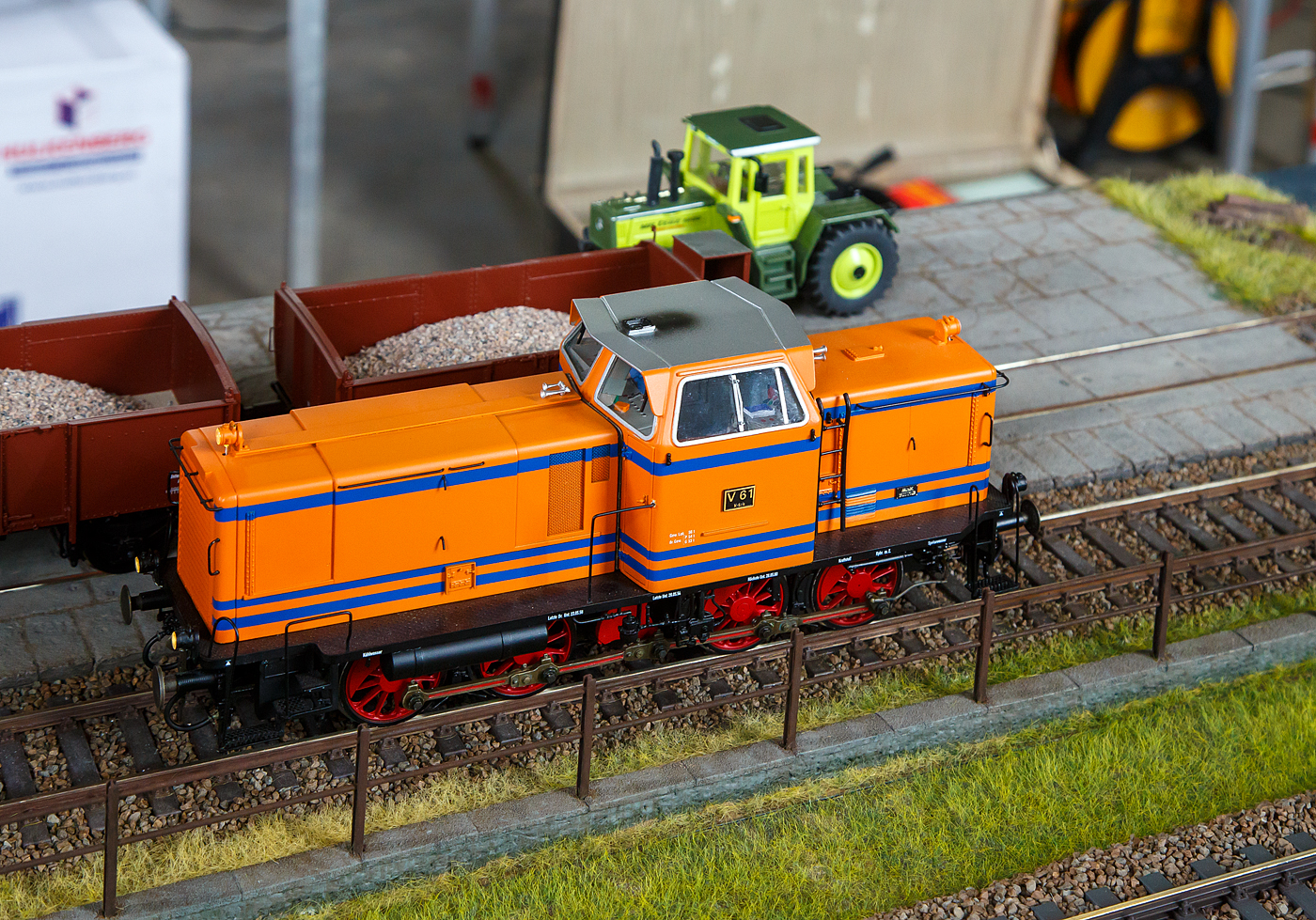 Als Spur 1-Modell, die ehemalige KSE V 61eine MaK 600D der Kiel-Schönberger Eisenbahn, zuvor Kleinbahn-AG Kiel–Schönberg), fährt am 02.07.2023 auf der Spur1-Anlage im Lokschuppen vom Erlebnisbahnhof Westerwald der Westerwälder Eisenbahnfreunde 44 508 e. V.,  hier war Lokschuppen-/Sommerfest. 

Das Original wurde 1955 von MaK in Kiel unter der Fabriknummer 500012 gebaut. Im Jahr 1983 ging über MaK und die IPE Locomotori S.p.A. nach Italien an die Cosfer (Tagliacozzo) als T 1545.

Den größten Bekanntheitsgrad erlangten die vierachsigen Stangenloks des ersten Typenprogramms. Wegen des langen Achsstandes waren die äußeren Radsätze mit Beugniot-Hebeln verbunden und seitenverschiebbar gelagert, um eine guten Kurvengängigkeit zu gewährleisten.

Während es anfänglich zwei verschieden Fahrwerke für die unterschiedlichen Leistungsklassen gab, so wurden ab 1957 auch die kleineren Loks mit dem längeren Fahrgestell der leistungsstärkeren Loks ausgeführt. Erkennbar ist dies an der Zahl der Lüftungsschlitze seitlich am langen Vorbau. Ein weiteres Merkmal der älteren Bauart sind die fehlenden Sonnenschutzdächer, was den Lokomotiven den Spitznamen  Glatzköpfe  einbrachte. Auch wenn hier das Spur1-Modell mit Sonnenschutzdächer ausgeführt ist, so hatte das Original keine und war ein „Glatzkopf“.

Aus der 600 D in ihrer ursprünglichen, kurzen Bauform wurde die V 65 für die DB entwickelt, bei der der MaK-Motor MS 301 C zum Einsatz kam.
