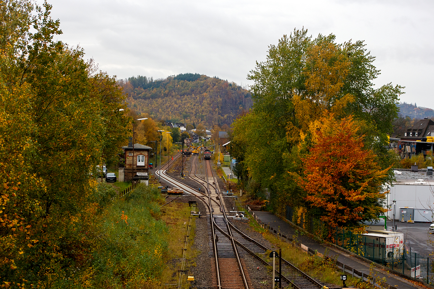 Baustelle Bahnhof Herdorf nun am Sonntagmorgen des 26 Oktober 2025, auch wenn es weithin k�hl und windig ist, so regnet es (kurzzeitig) wenigstens mal nicht. Doch trotz der bescheidenen Wetterverh�ltnisse, sind die Arbeiten seit gestern Nachmittag sehr gut vorangegangen. Die neue Weiche 3 und das neue Gleis als Anschuss von Weiche 26 an Gleis 4 sind eingebaut. Nun muss noch Eingeschottert und sp�ter Gestopft werden. 

Zurzeit werden die alten ausgebauten Gleis- und Weichenst�cke zerlegt und mittels Zweiwegebagger auf Res-Flachwagen verladen. Vor dem Zug befindet sich die Vossloh G 12 – 4120 001-7 „Karl August“ (92 80 4120 001-7 D-KAF) KAF Falkenhahn Bau AG.