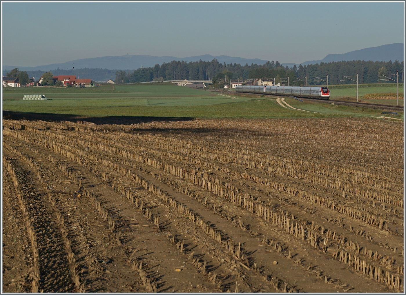 Bei Bolken fährt ein ICN 500 auf dem Weg vom Lac Léman zum Bodensee durchs Mittelland. Was das beschauliche Bild nicht zeigt, ist dass der ICN mit gut 200 km/h über die Ausbaustrecke in Richtung NBS fährt! Geleise liegen hier schon lange: Die 1857 eröffnete Strecke von Herzogenbuchsee nach Solothurn war eine wichtige Verbindung in die Westschweiz bis 1876 die Gäubahn nach  Neu Solothurn  nach kaum zwanzig Jahren zur Nebenbahn degradierte. Noch bis 2004 hielt sich die Strecke und beim Bau der Anbindung von Solothurn zur NBS wurde auf dem Abschnitt Solothurn - Inkwil das Trasse der alten  Buchsibahn  genutzt. 

12. September 2022