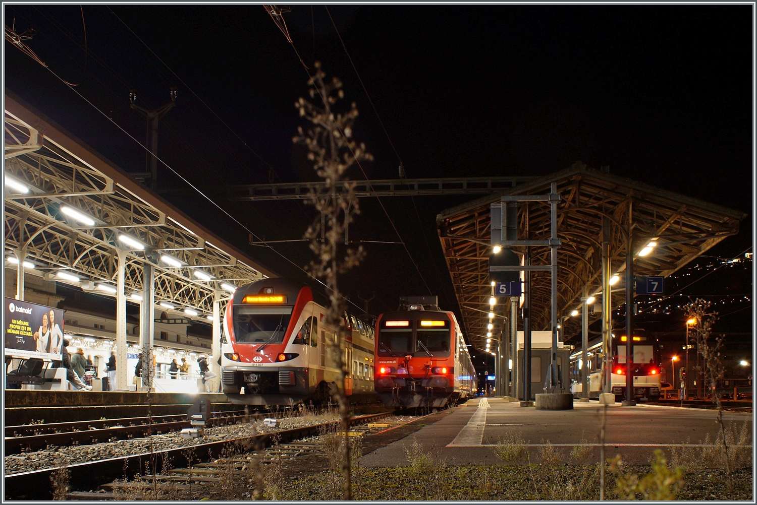 Beim Umsteigen in Vevey nach der Arbeit versuchte ich noch die  Bonne Année 2024  Anschrift festzuhalten, dies jedoch mit eher mässigem Erfolg. Bei der Aufnahme nicht gesehen hatte ich den kleine Strauch direkt vor der Kamera, der erst beim Bearbeiten auftauchte! 
Trotzdem finde ich die Stimmung zeigenswert. Im Bahnhof von Vevey stehen der SBB RABe 511 037 nach Annemasse, ein SBB Domino, der auf der  Train de Vignes  Linie im Einsatz ist und etwas verdeckt ein CEV MVR ABeh 2/6 nach Les Pléiades. 

1. Jan. 2024