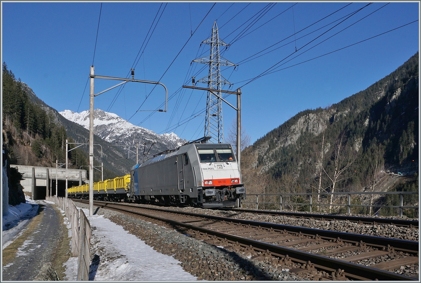 Da der 1981 er�ffnete Strassen Gotthardtunnel saniert werden muss, leistet man sich den Luxus, f�r die Zeit der Sanierung eine zweite R�hre zu bauen. Nach der Sanierung werden beide R�hren durch den richtungsgetrennten Verkehr mehr Sicherheit bieten, d�rfen aber nur eine Spur pro R�hre aufweisen, es wird interessant sein, ob dies dann auch eingehalten werden wird...
Das Aushubmaterial wird per Bahn nach Fl�elen transportiert. Das Bild zeigt die Railpool 186 110 mit einem aus Sggrrs S204 Wagen gebildeten Ganzzug kurz vor G�schenen. 

21. Januar 2025