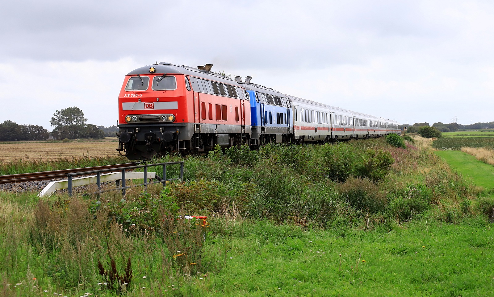 DB 218 390-3 BCS X/23.04.19 und PRESS 218 058-9/218 412-5 LS X/30.05.22 mit IC 2214 auf dem Weg nach Westerland. Bü Triangel 13.08.2023