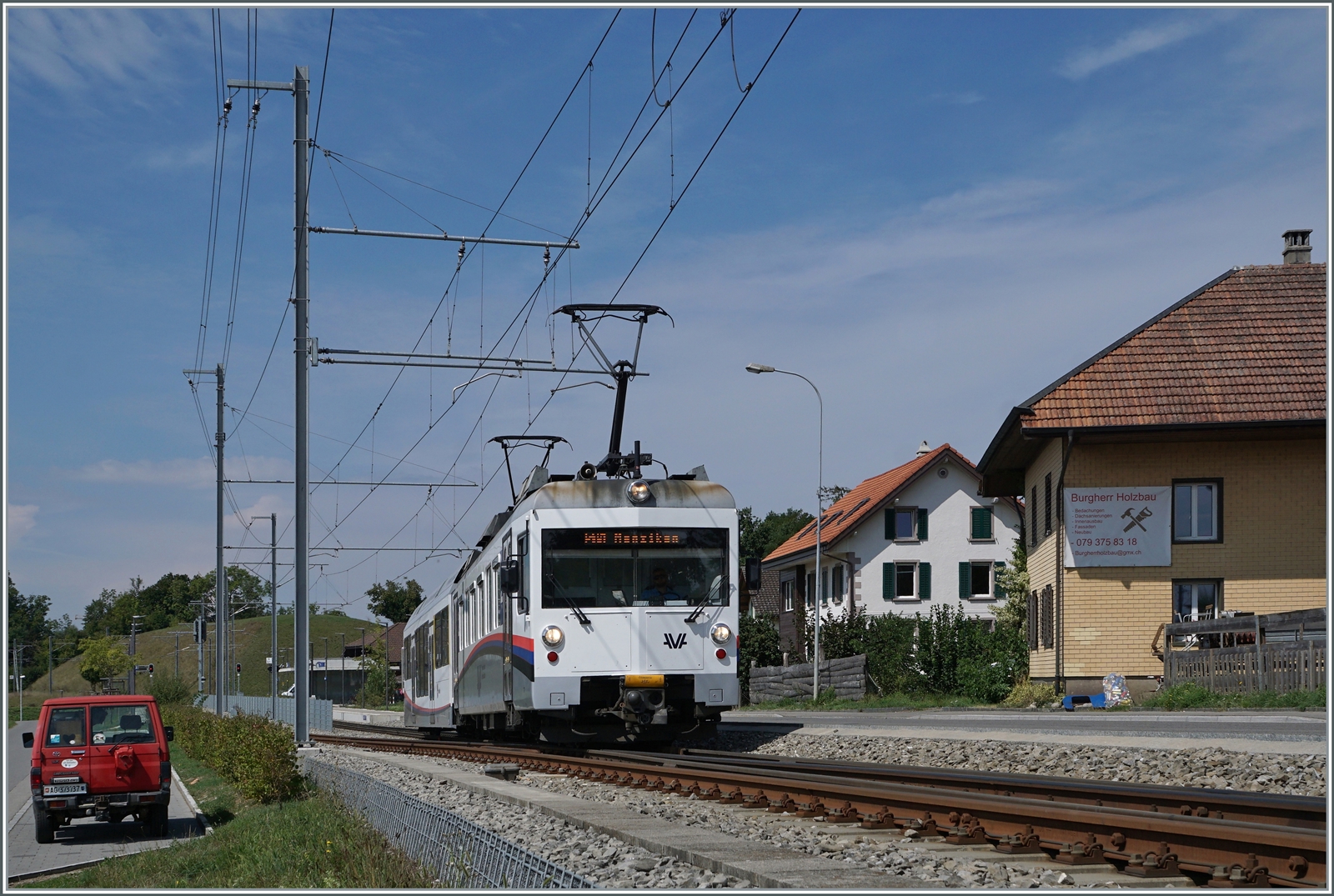 Der AVA (ex WSB/AAR) Be 4/4 17 ist mit einem wenig passenden Steuerwagen in Zetzwil auf dem Weg nach Menziken. 

26. Aug. 2022